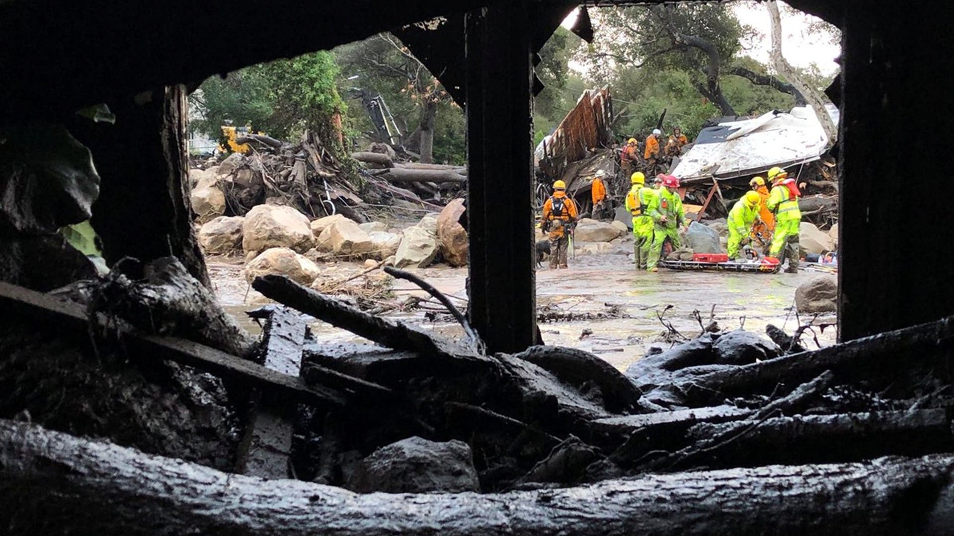 Emergency personnel search through debris and damaged homes after a mudslide in Montecito, January 9, 2018
