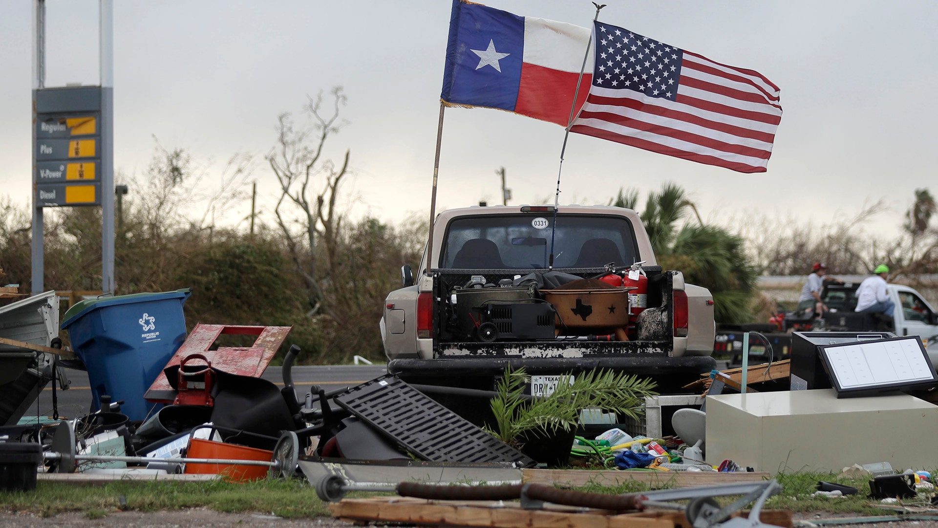 The Texas state flag and American flag wave over an area of debris left behind in the wake of Hurricane Harvey, Sunday, in Rockport, Texas