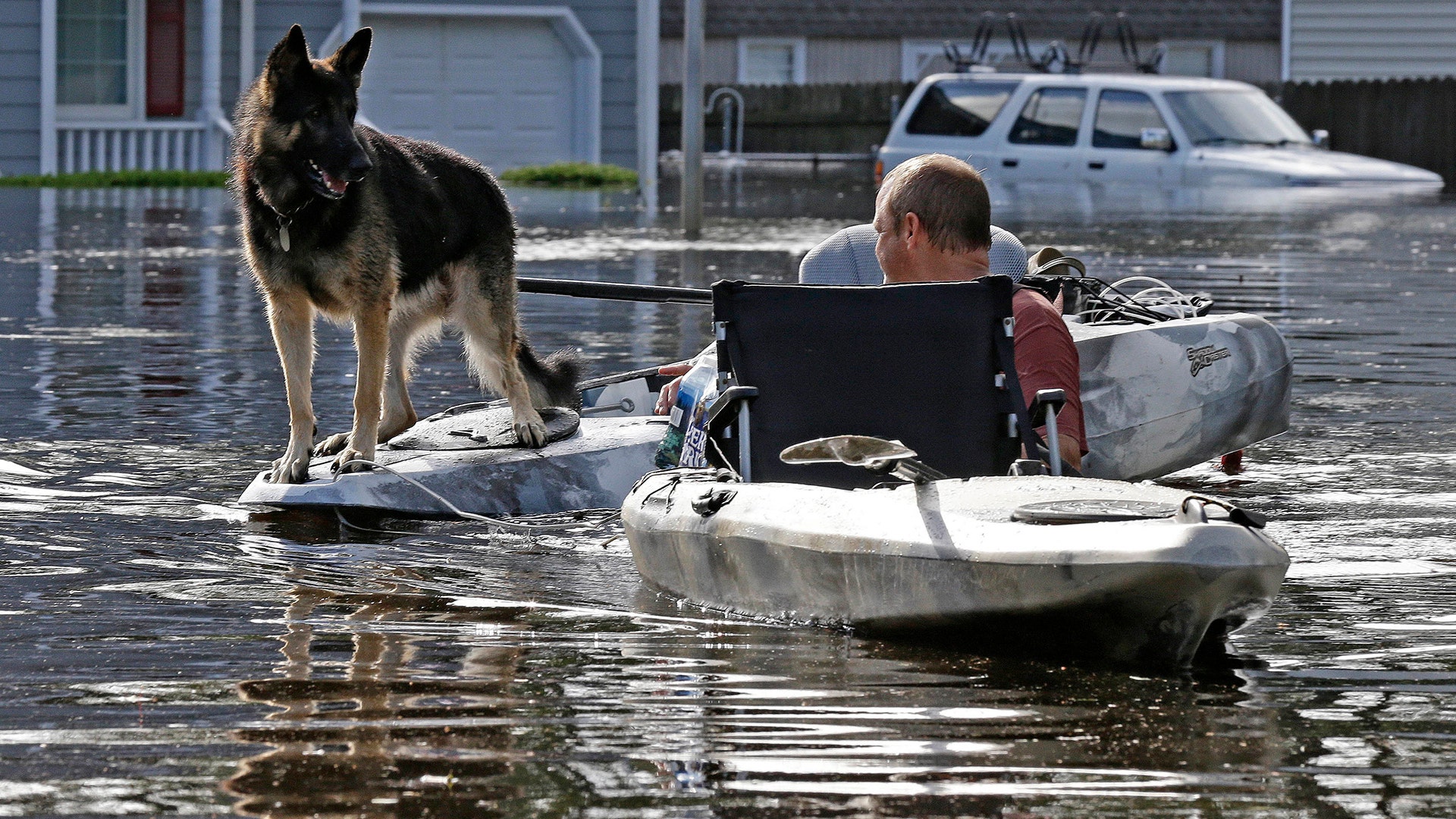 A man in North Carolina tries to get his dog out of a flooded neighborhood in Lumberton on Monday.