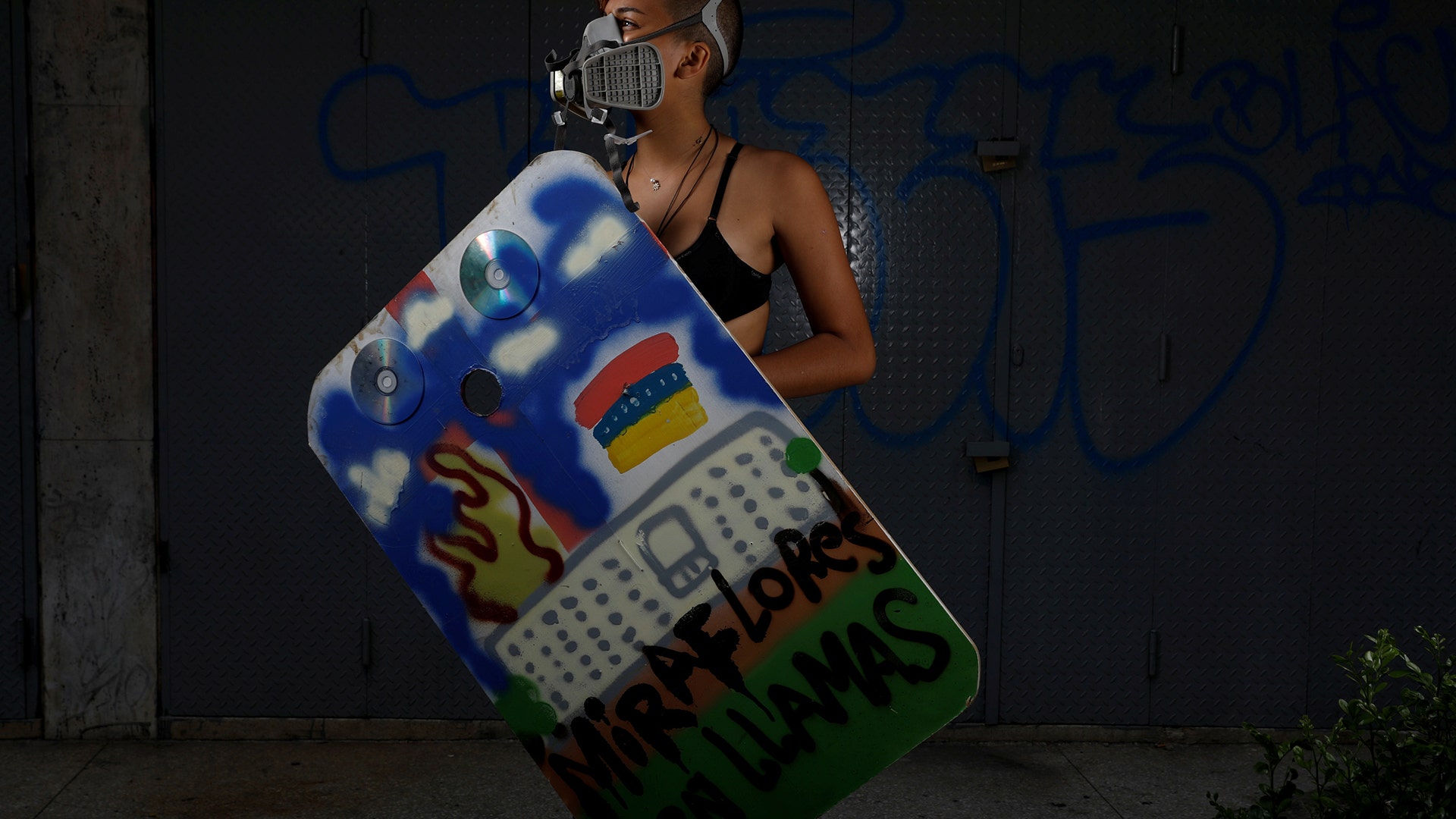 A demonstrator holding a rudimentary shield that reads