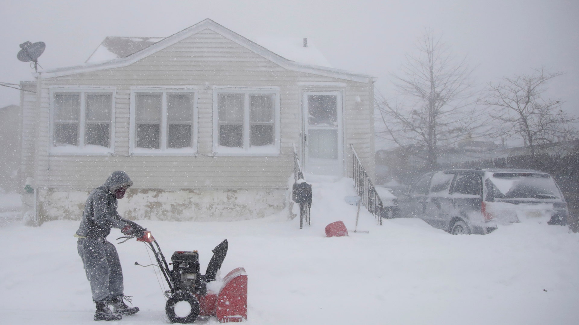 Gilberto Colin gets a head start on snowplowing his property during the middle of a snowstorm,  in Neptune, N.J., Thursday