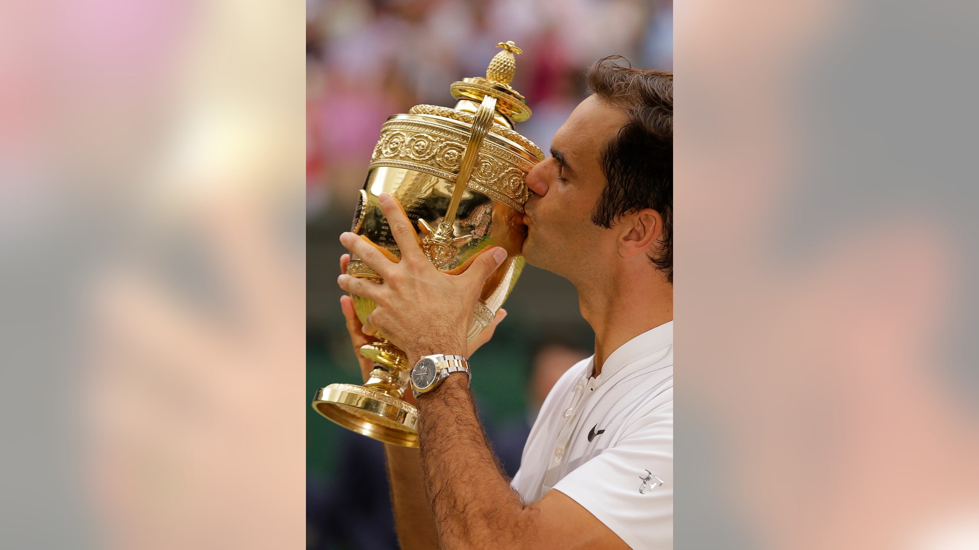 Switzerland's Roger Federer kisses the trophy after defeating Croatia's Marin Cilic to win the Wimbledon men's singles title