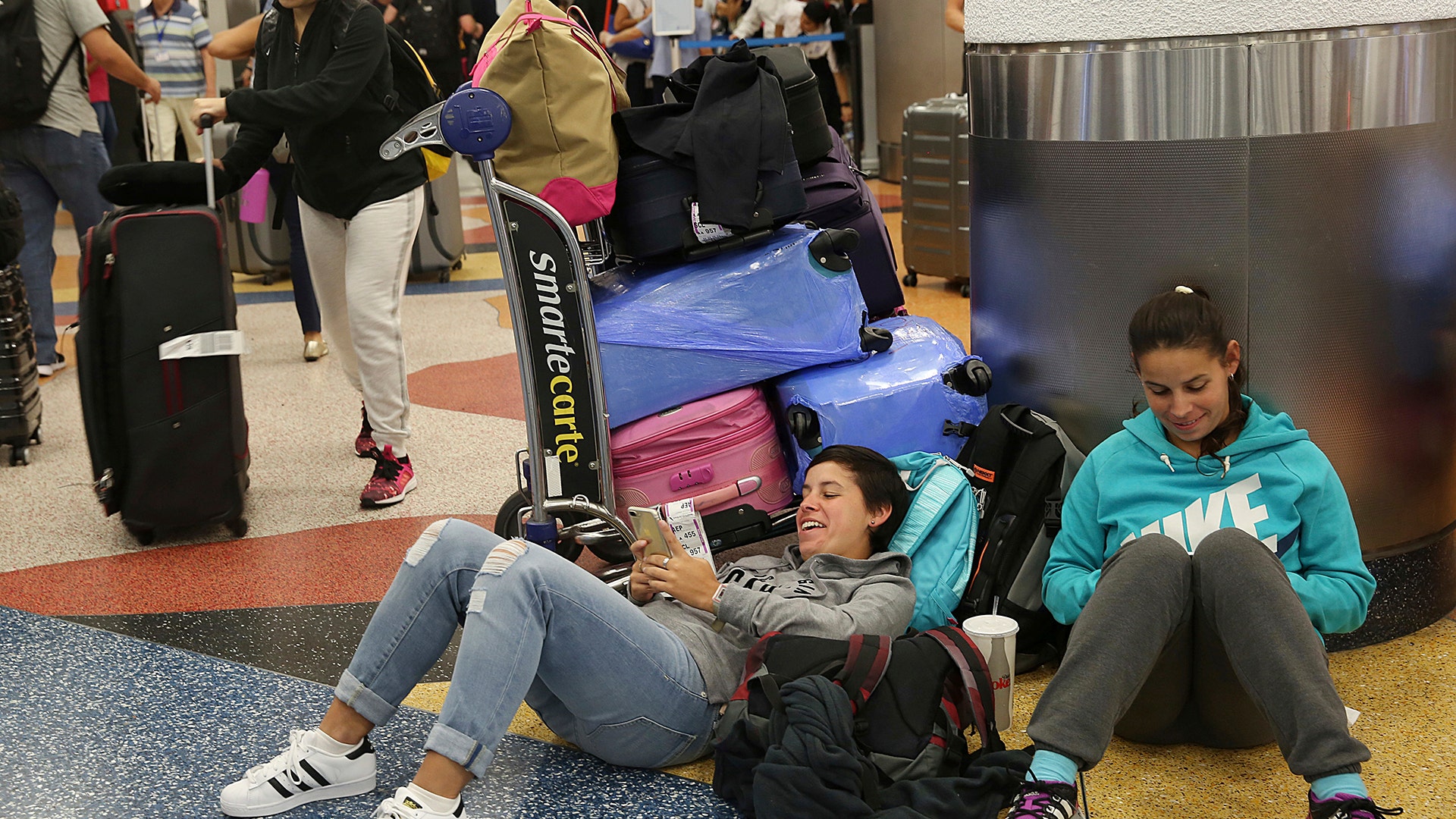 Yanina Fernandez and her sister Liz wait for a flight to Argentina after their flight was cancelled at Miami International Airport, Thursday