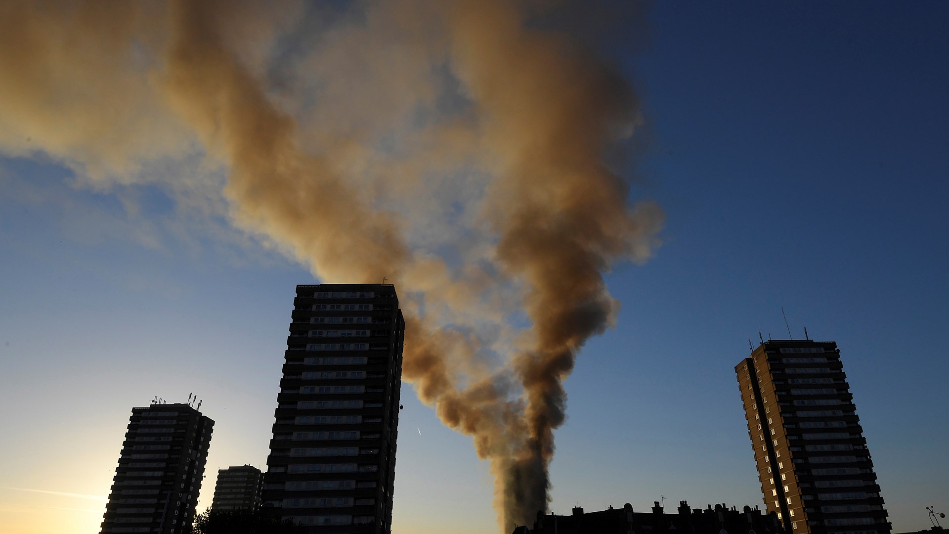 Smoke billows from the apartment building on fire in West London