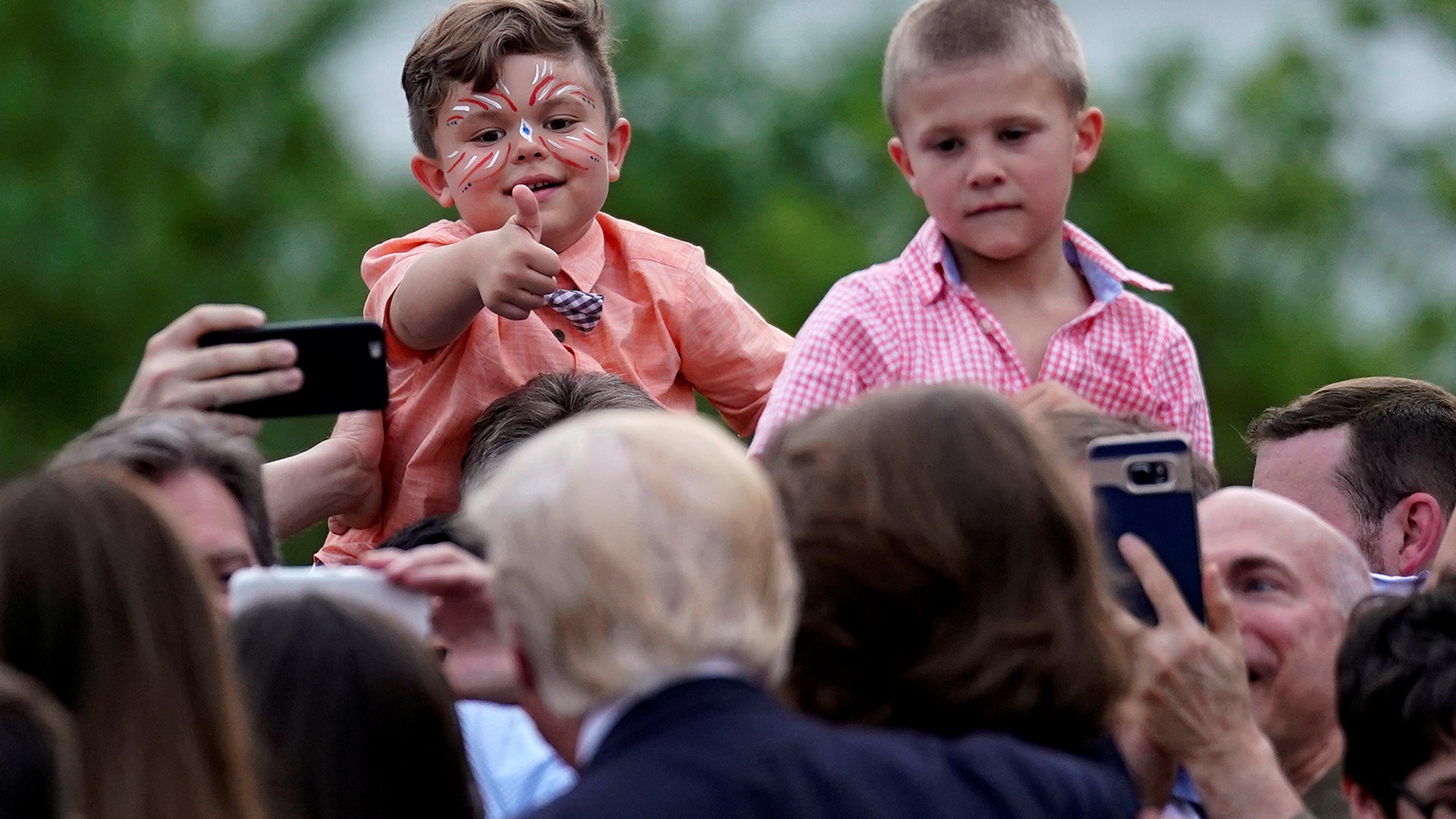 A boy gives gives a thumbs-up to U.S. President Donald Trump at the Congressional Picnic