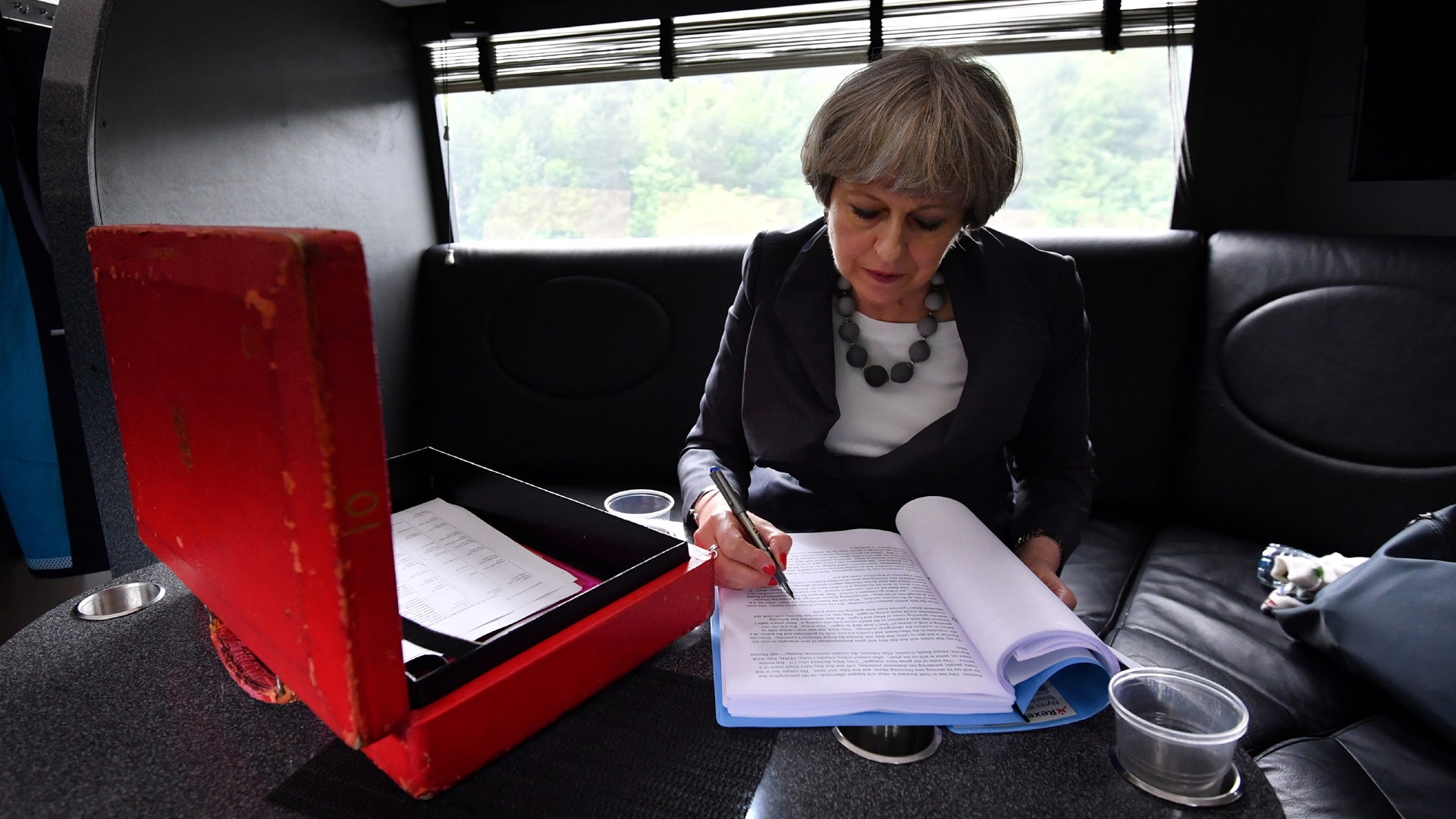 Britain's Prime Minister Theresa May works on her campaign bus as it travels through Staffordshire