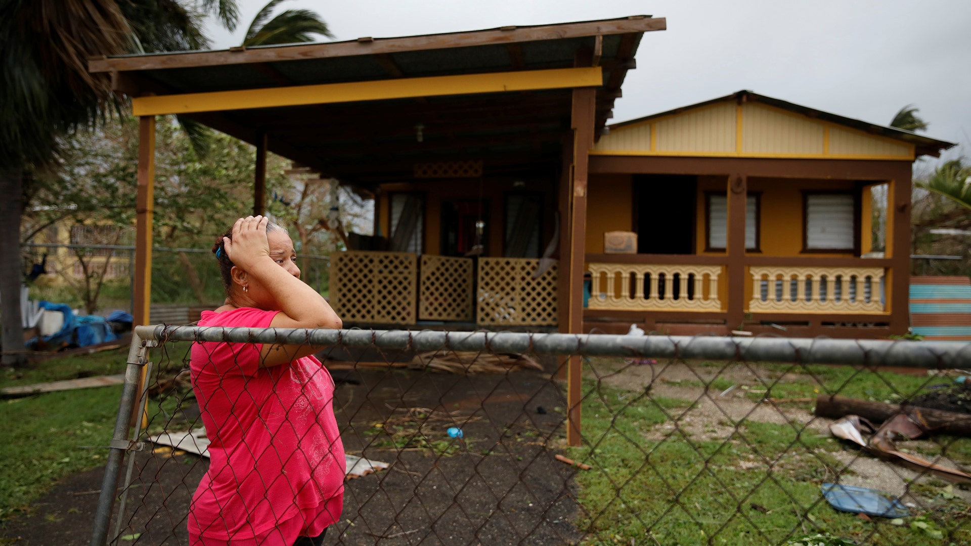 A woman reacts while looking at the damage to her house after the area was hit by Hurricane Maria in Guayama, Puerto Rico, Wednesday