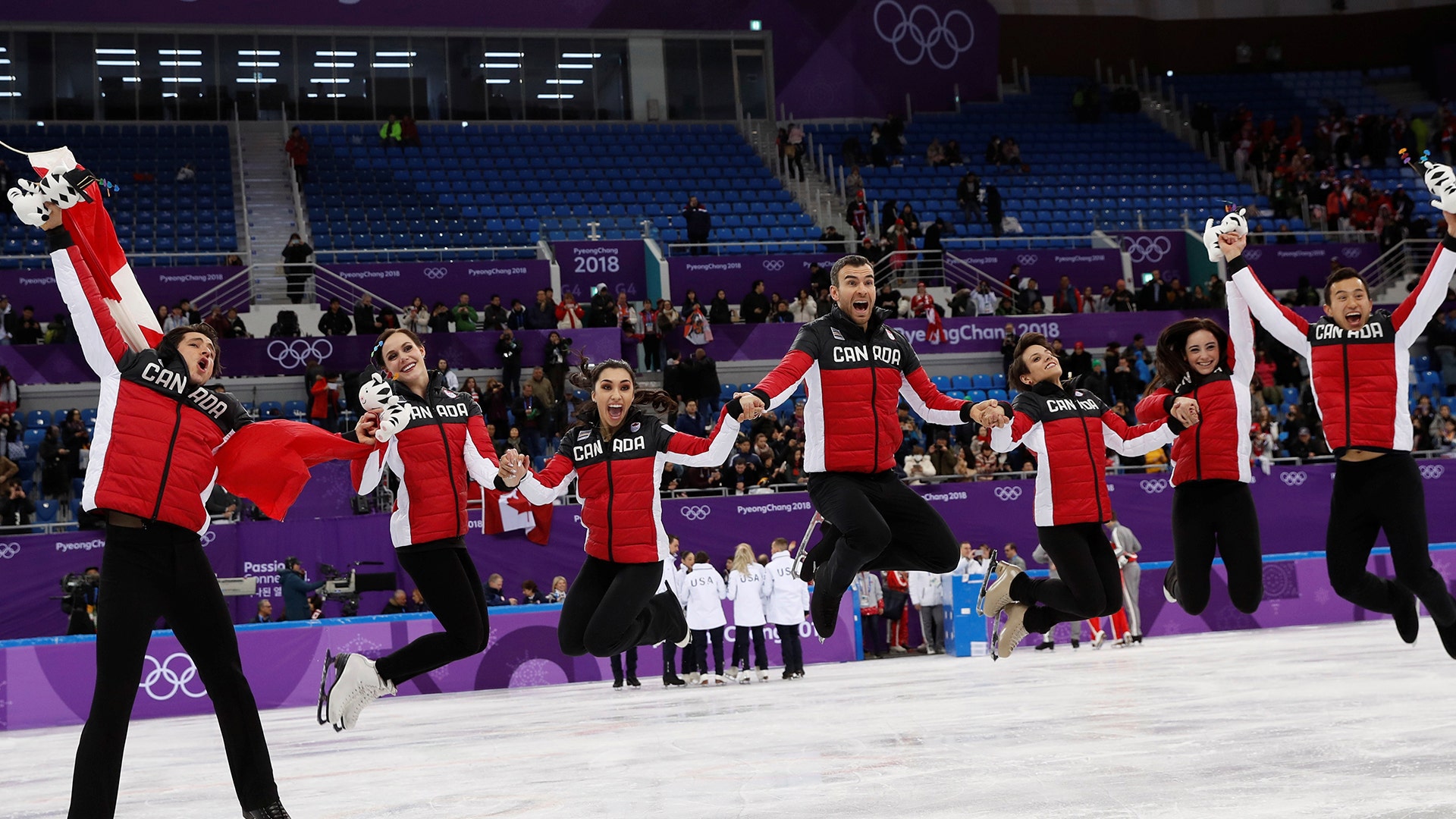 Canadian figure skaters celebrate winning the gold medal in the team event at the 2018 Winter Olympics