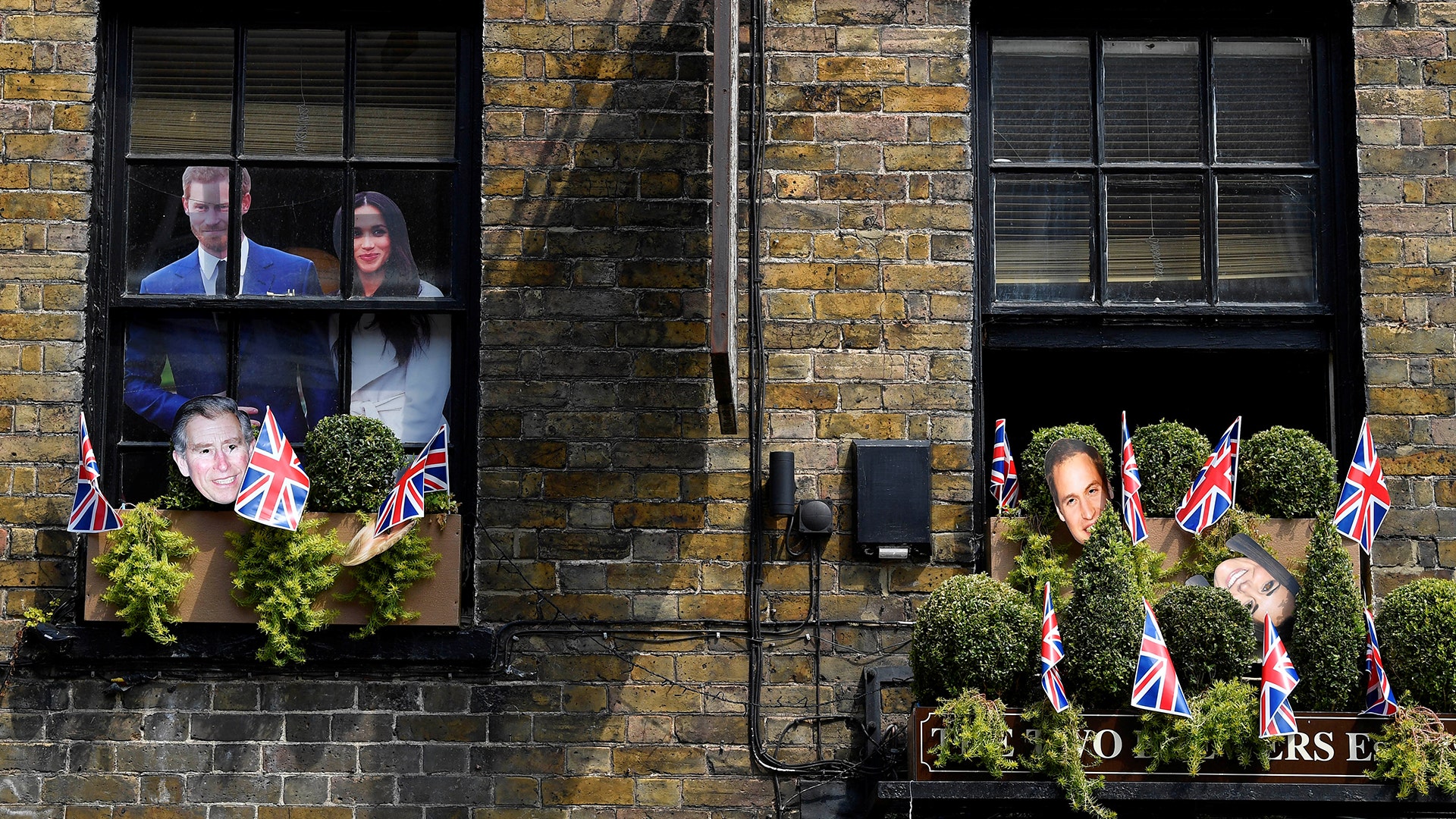 Pictures of Prince Harry and his fiancee Meghan Markle are seen in a pub window near Windsor Castle in Windsor, Britain, May 8, 2018