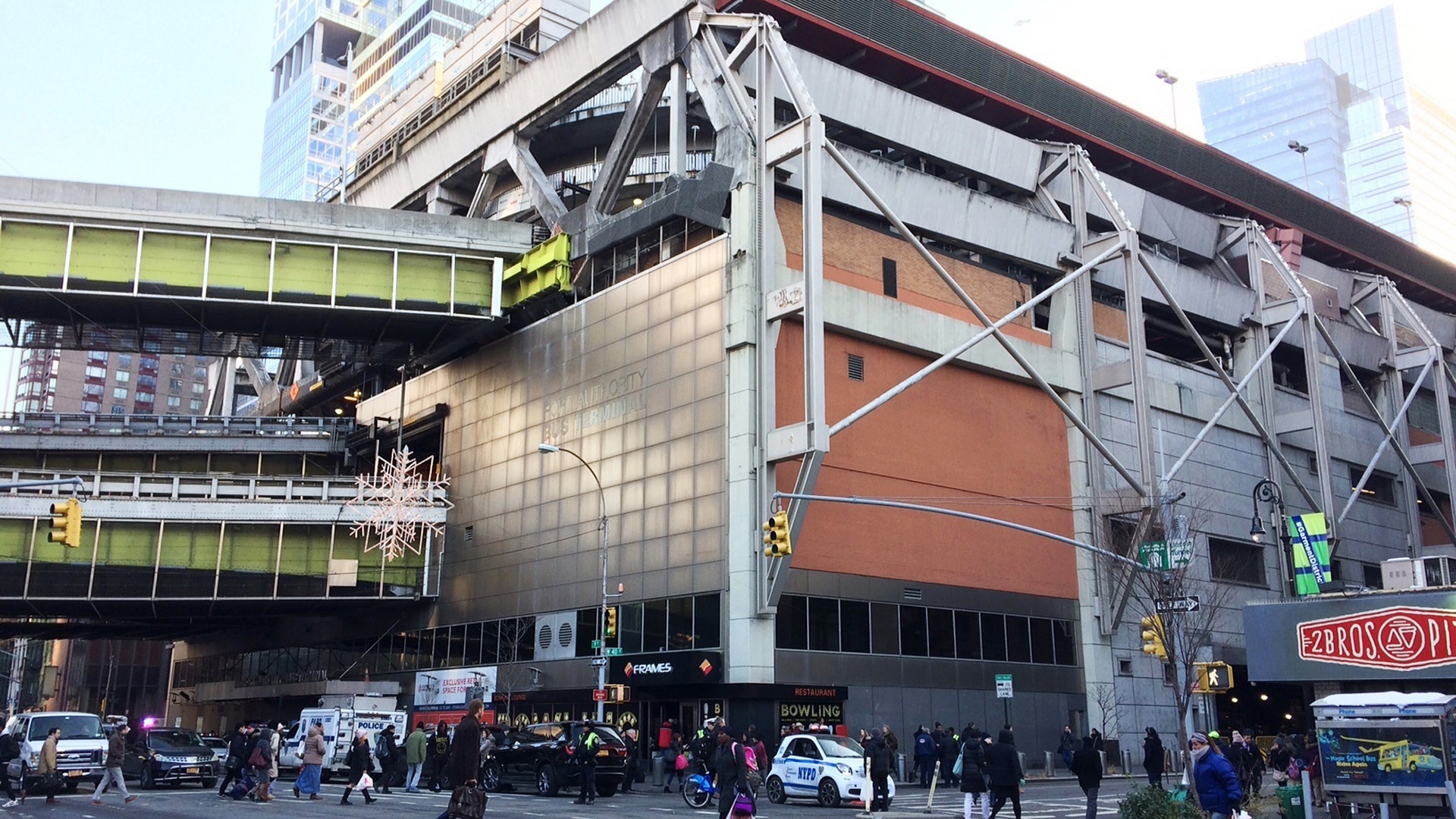 People walk past Port Authority Bus Terminal as police respond to an explosion near Times Square in New York City, Monday