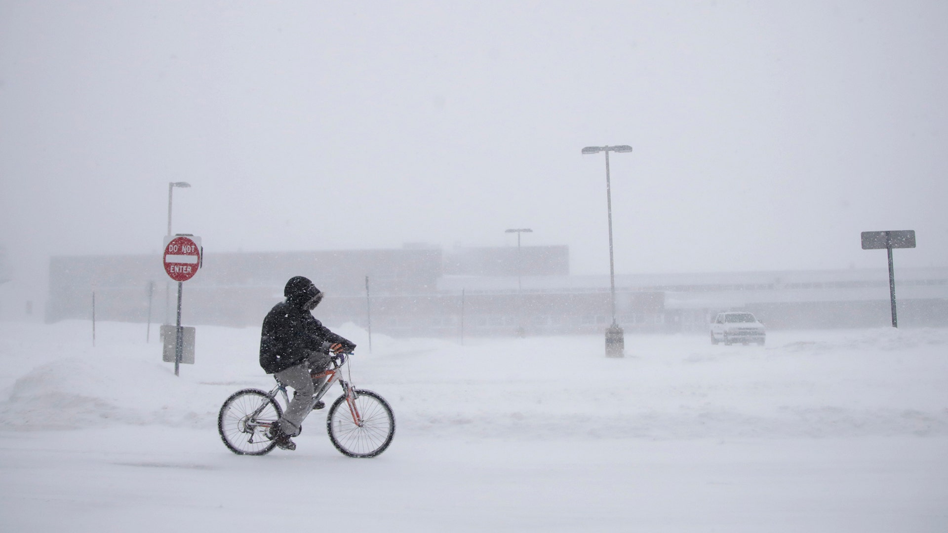 Justin Hartman rides his bicycle along New Bedford Road in whiteout conditions during a snowstorm, in Wall Township, N.J., Thursday