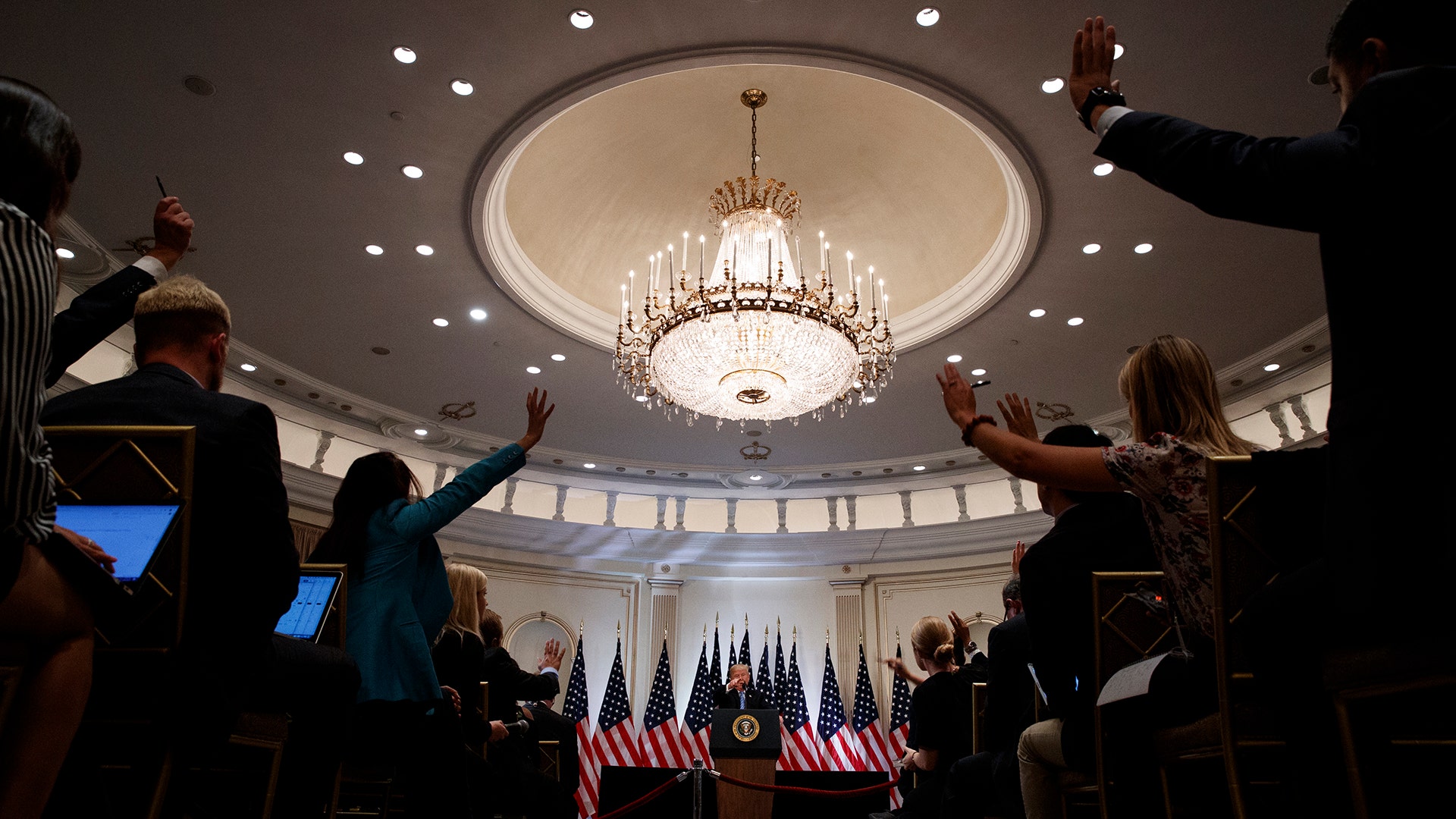 Reporters raise their hands to ask a question as President Donald Trump speaks during a news conference in New York, September 26, 2018