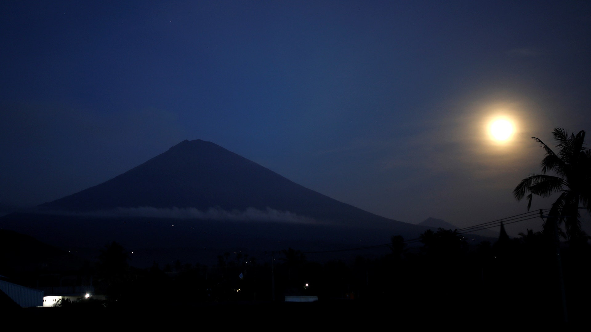 The full-moon is seen along with Mount Agung volcano, from Amed in Karangasem Regency, Bali, Indonesia, December 4