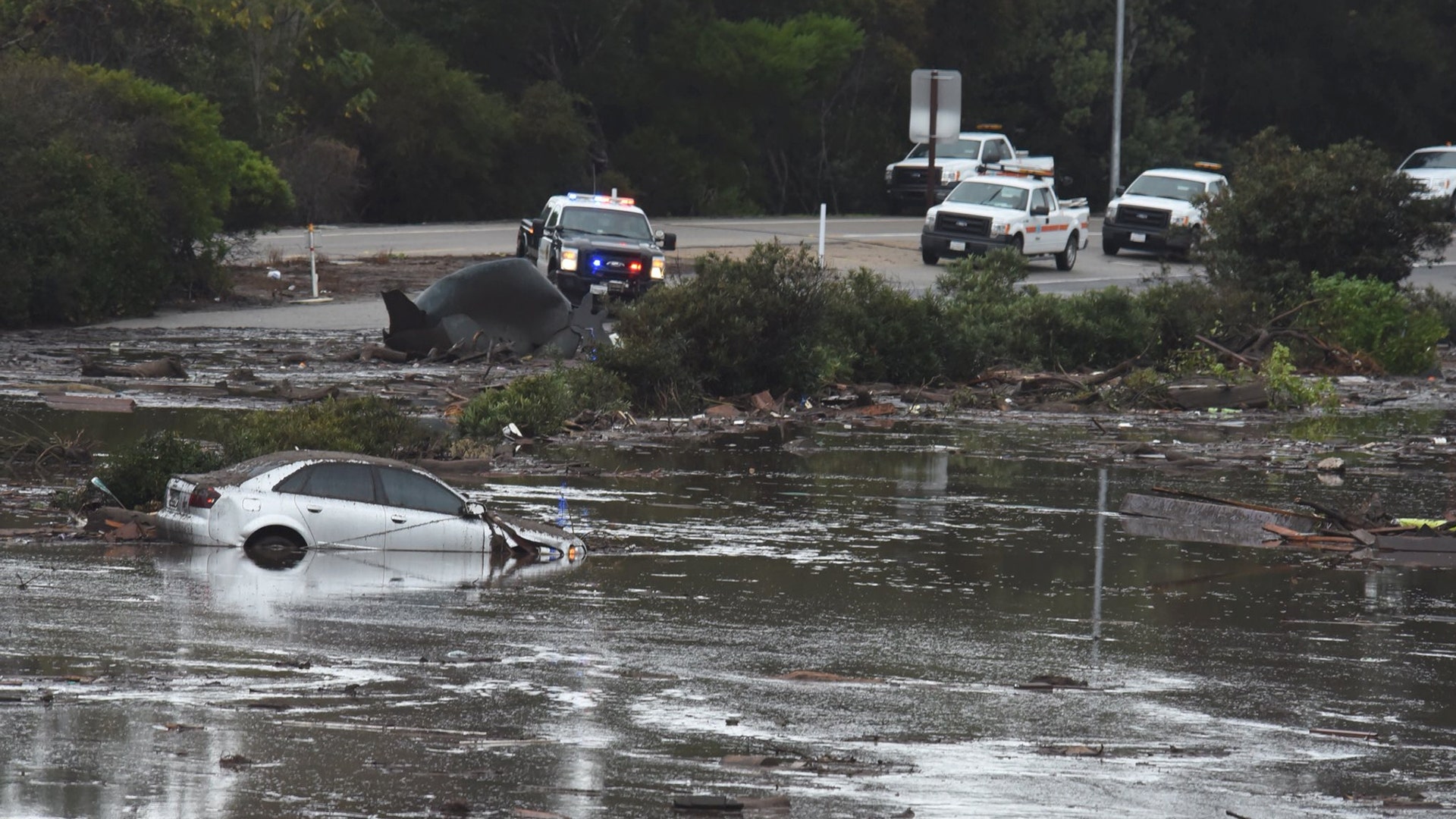An abandoned car floats in flooded waters and debris on the freeway after a mudslide in Montecito, California, January 9, 2018
