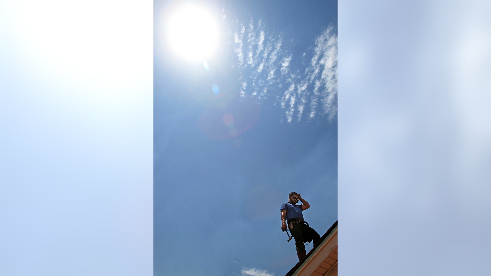 Julio Ruiz of J.R.R. Roofing pauses in the heat as the temperature approaches 115-degrees in Tucson, Tuesday