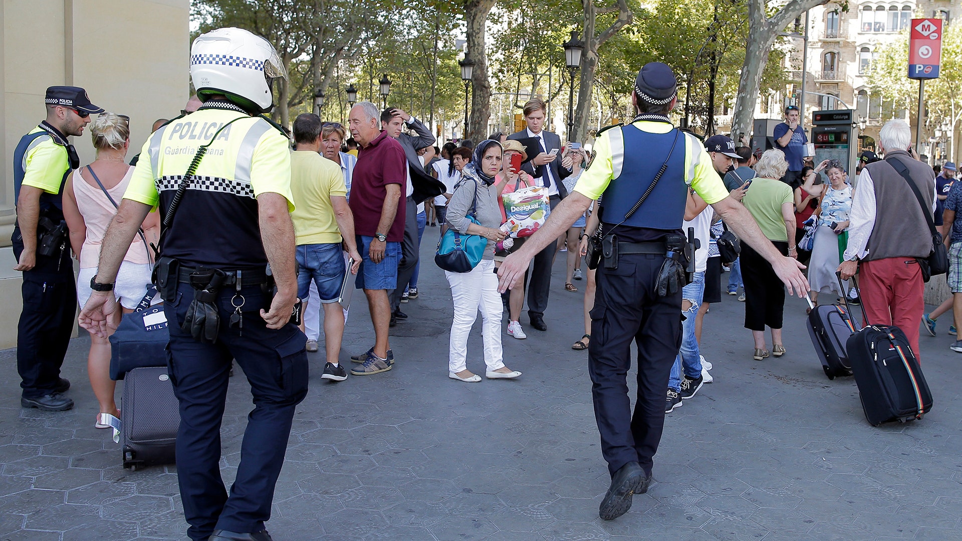 Police keep people back after a van crashed into a crowd of residents and tourists on Las Ramblas in Barcelona, August 17