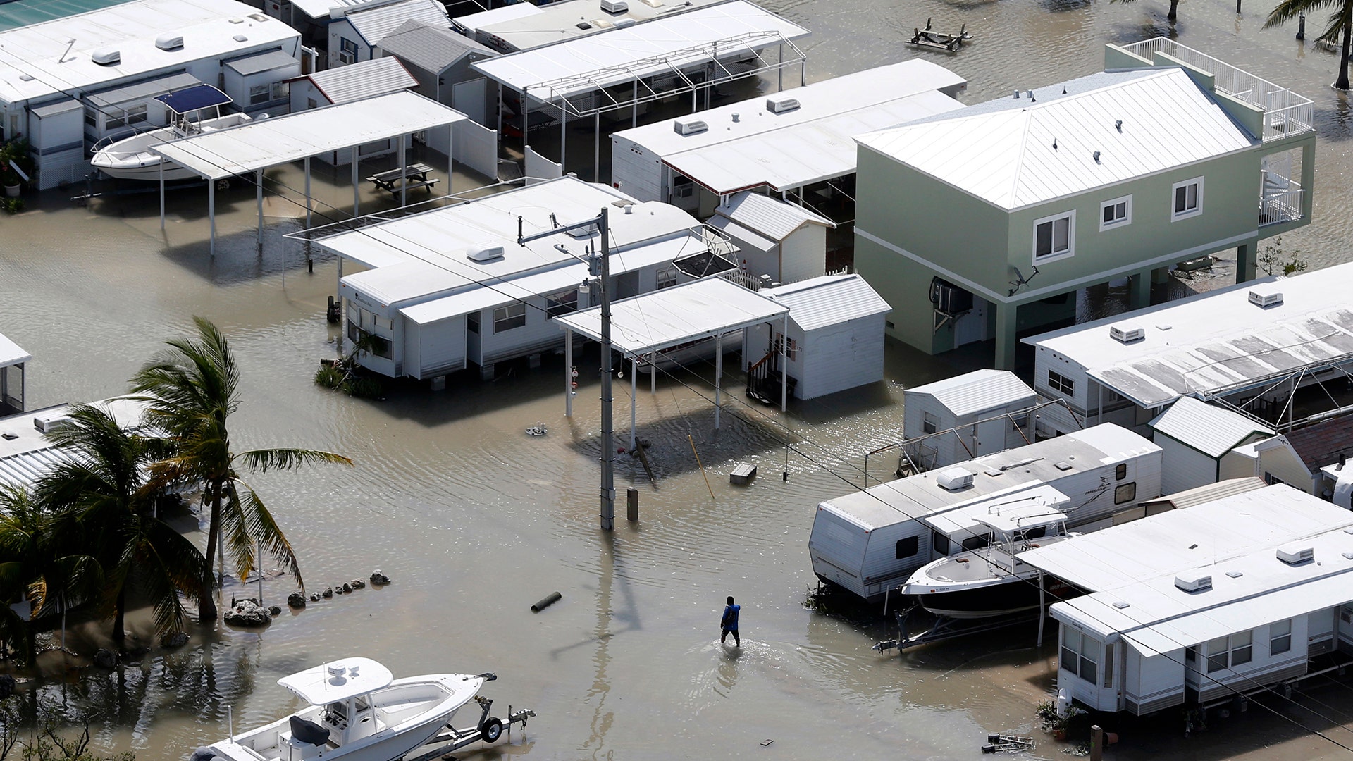 A person walks through the flooded streets of a trailer park in the aftermath of Hurricane Irma, Monday