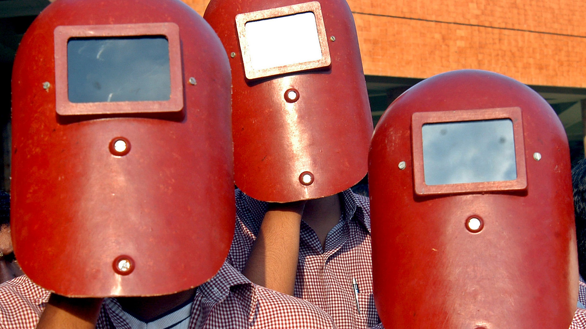 Indian students use welders masks to view the annular solar eclipse over the southern Indian city of Chennai, October 3, 2005