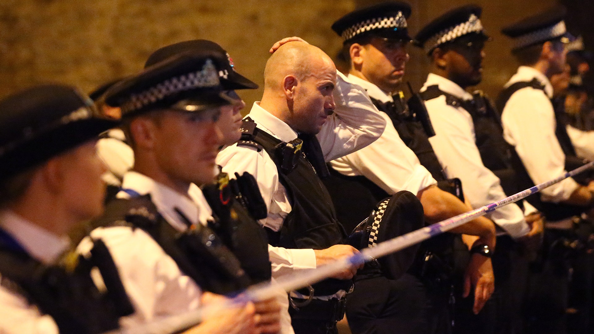 Police officers attend to the scene after a vehicle collided with pedestrians near a mosque in the Finsbury Park neighborhood of London