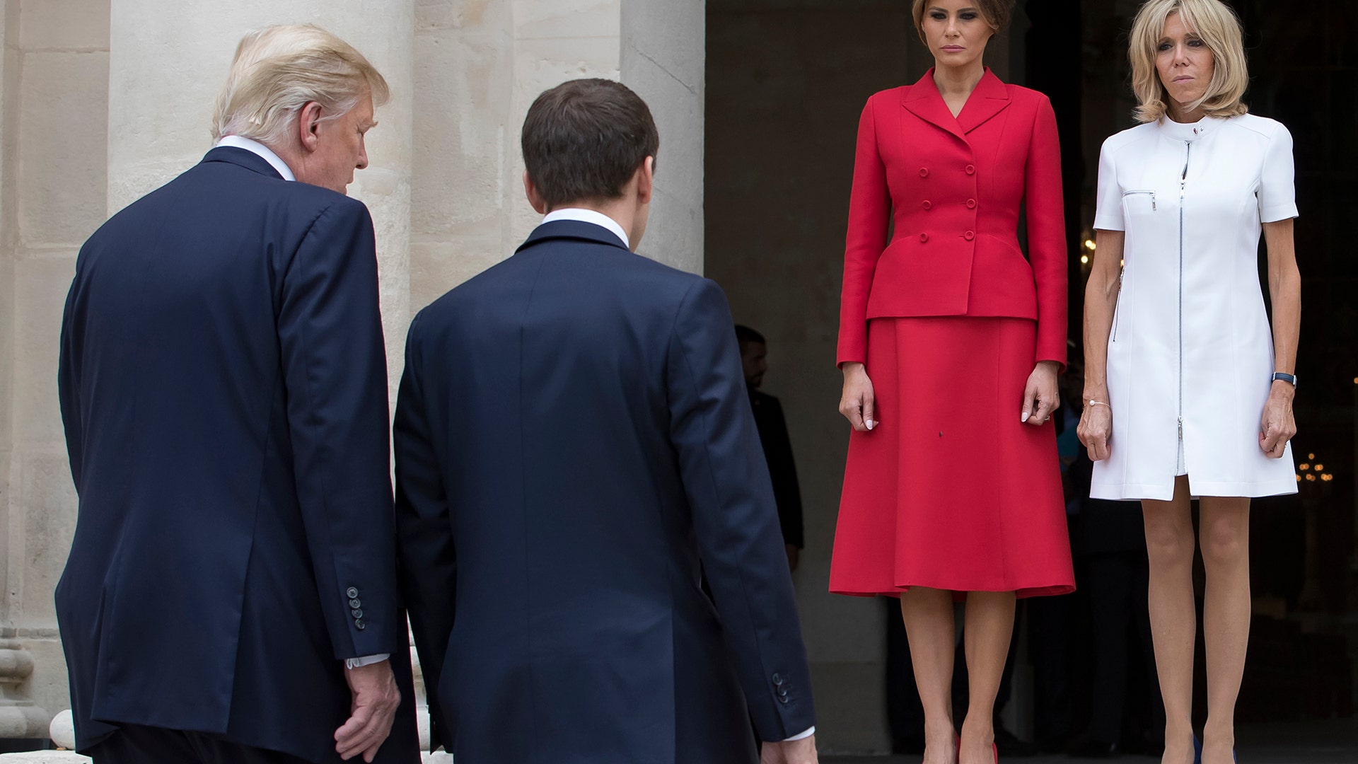 French President Emmanuel Macron and President Donald Trump walk to their wives Melania Trump and Brigitte Macron at Les Invalides