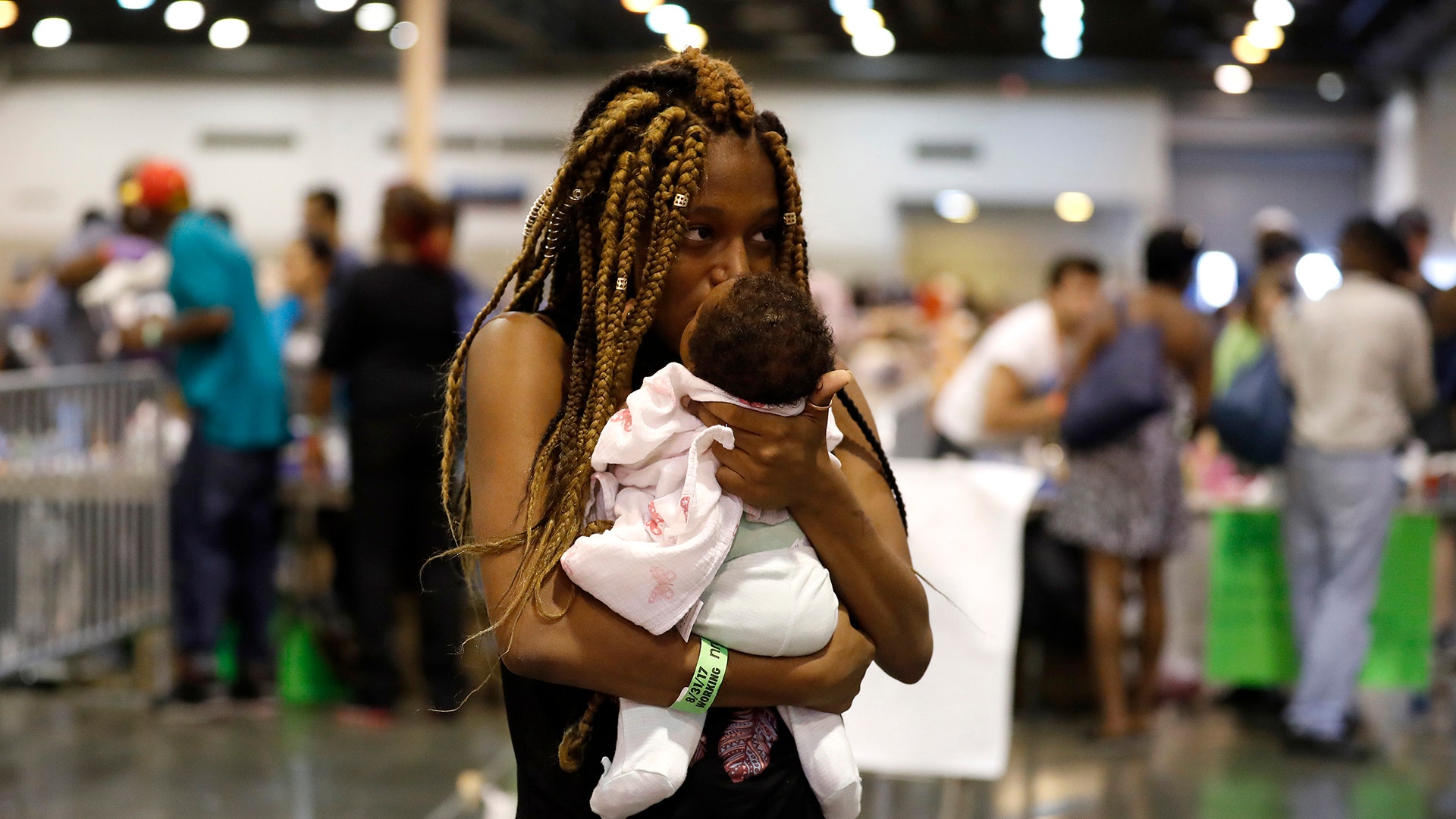 Shaqualia Watkins comforts her one-month-old daughter, Kamarii, as she and other evacuees stay at NRG Center, Wednesday, in Houston