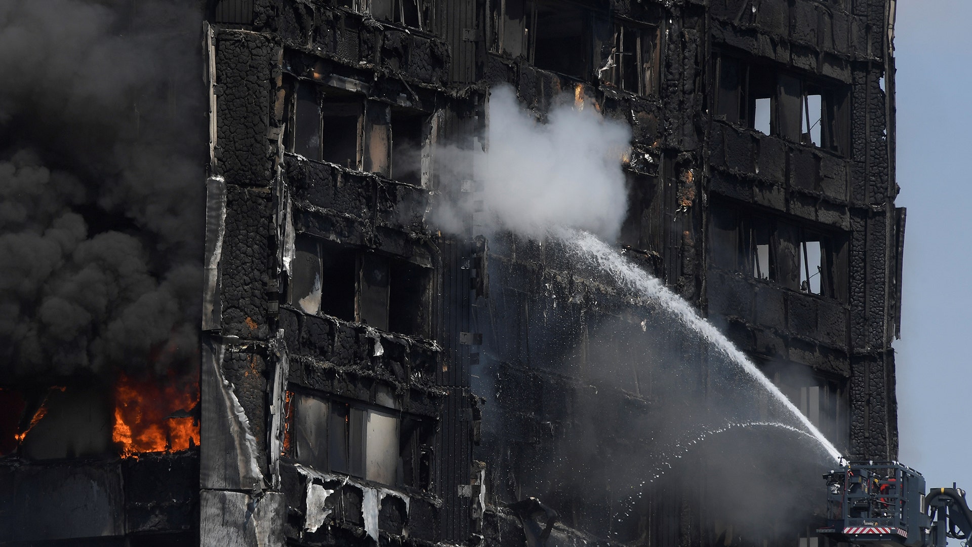 Firefighters direct jets of water onto an apartment block during the fire in West London
