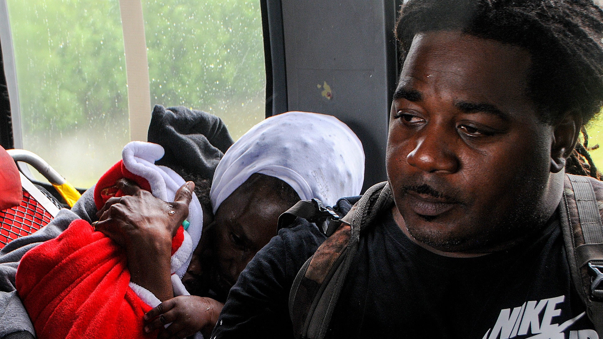 A family sits in the cabin of an HH-60 Pave Hawk helicopter, operated by Airmen of the 106th Rescue Wing