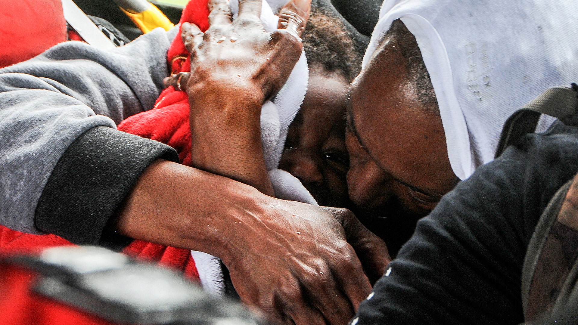 A woman coddles a child in the cabin of the HH-60 Pave Hawk helicopter