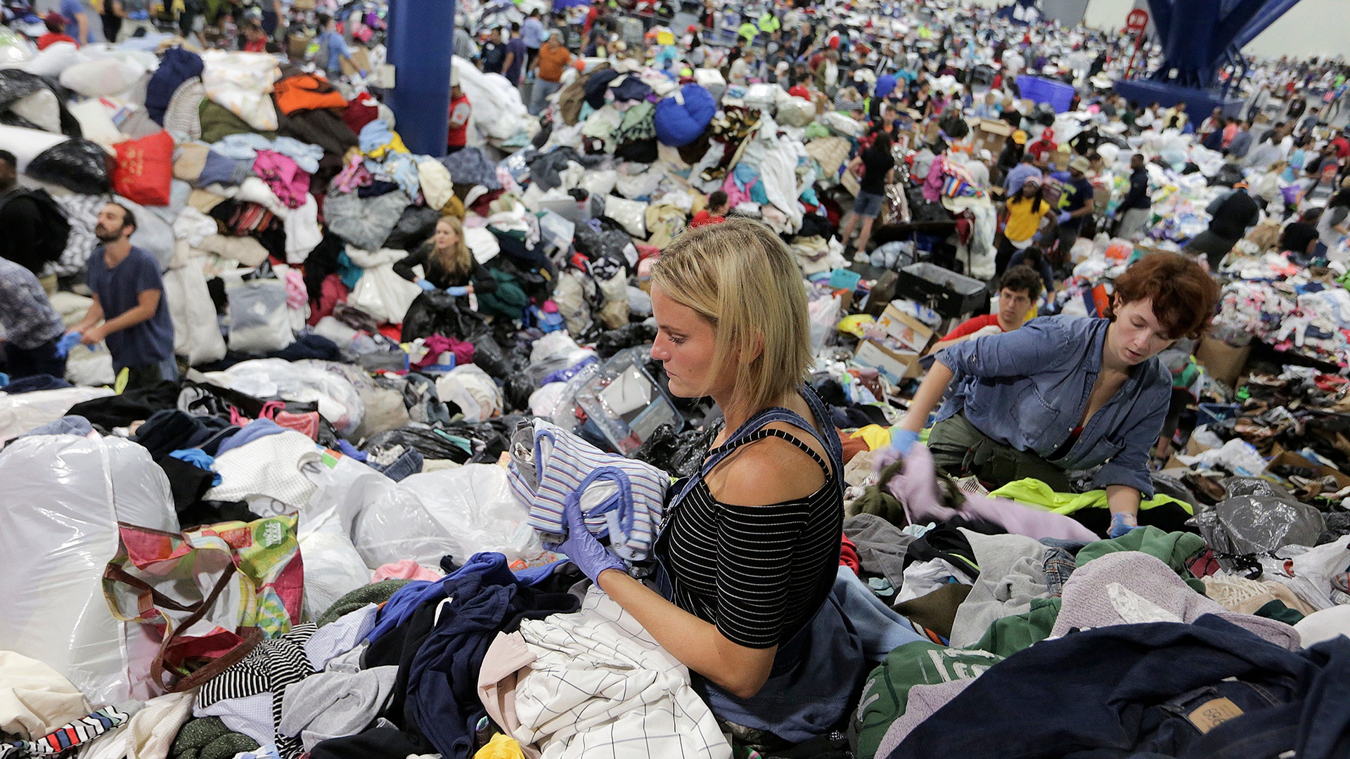 Kathryn Loder sorts donated clothing at George R. Brown Convention Center in Houston, Tuesday