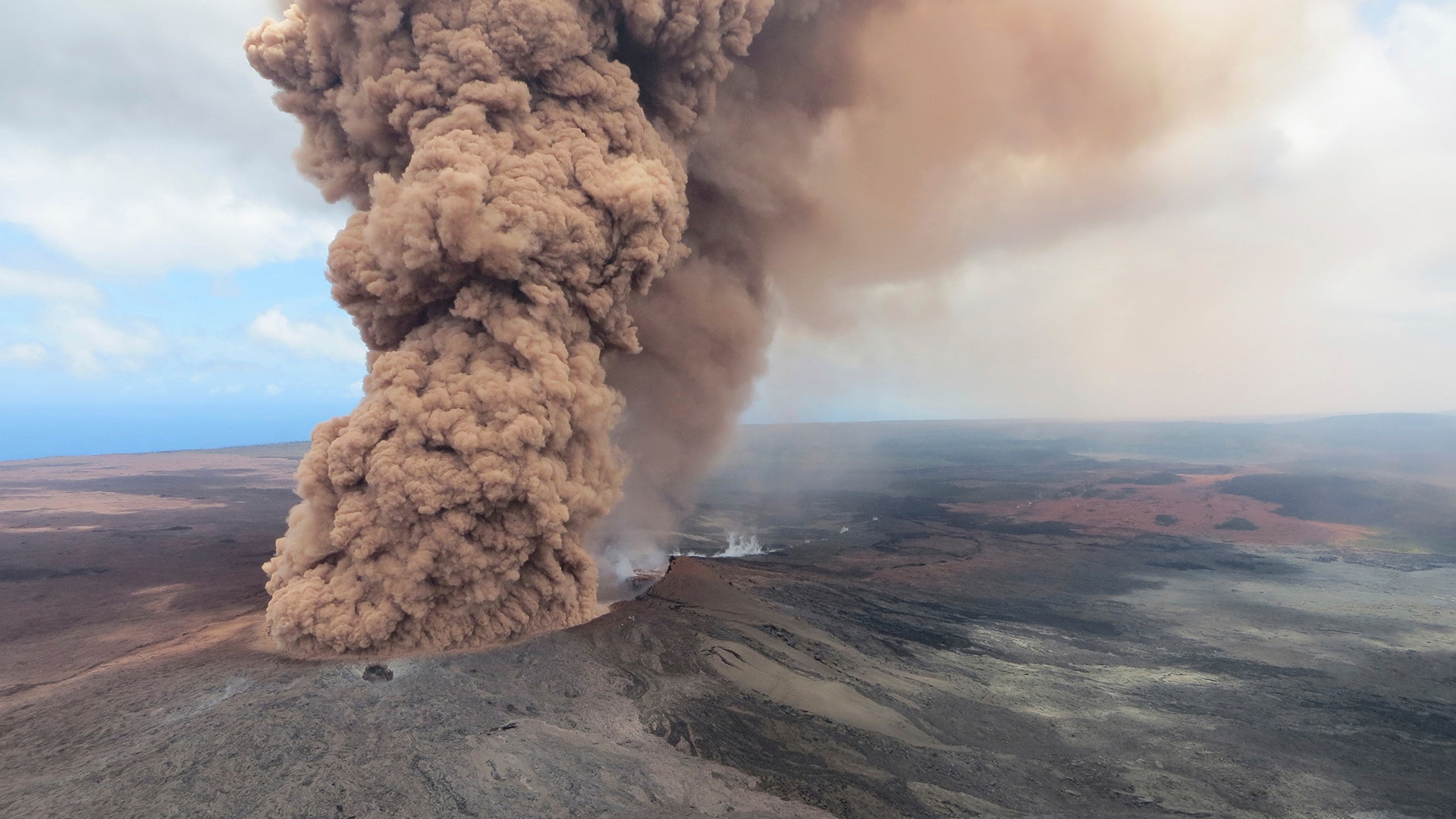 A reddish-brown ash plume rises after a magnitude 6.9 south flank of Kīlauea earthquake shook the Big Island of Hawaii, May 4, 2018
