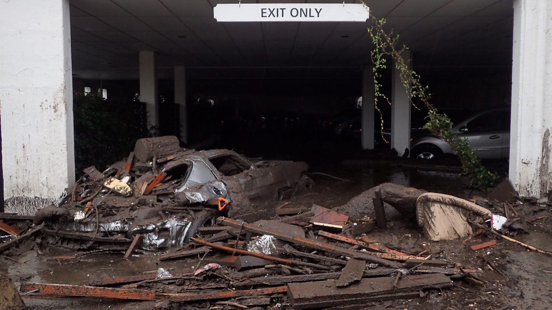 A damaged car carried by mud flow, floats in flooded waters and debris after a mudslide in Montecito, January 9, 2018