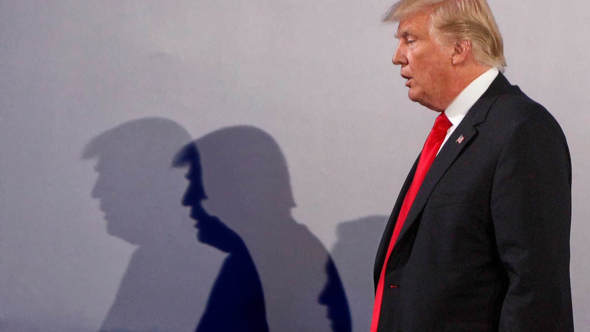 President Donald Trump casts shadows on the wall at the end of a joint press conference with Poland's President Andrzej Duda, in Warsaw