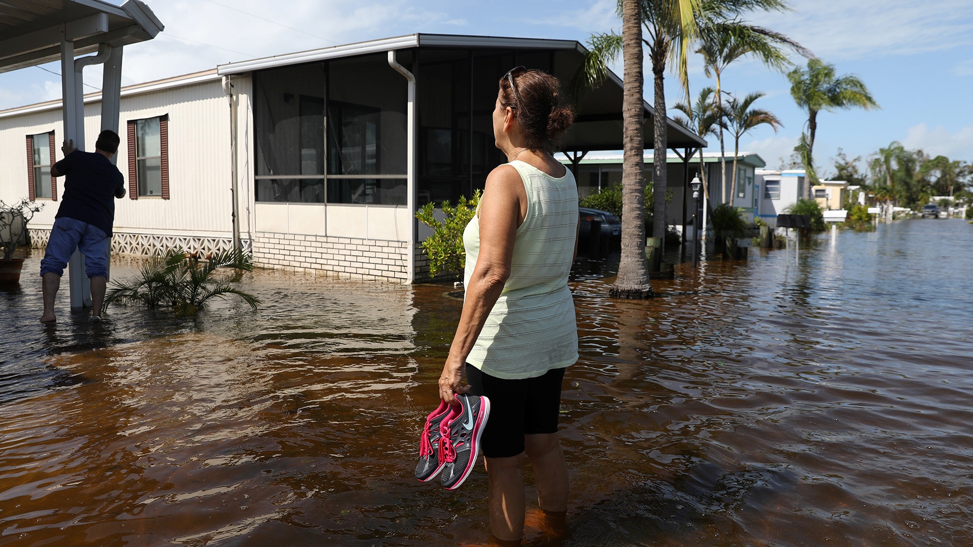 Marie Powell surveys damage to her property at a mobile home park after Hurricane Irma in Naples, Florida, Monday