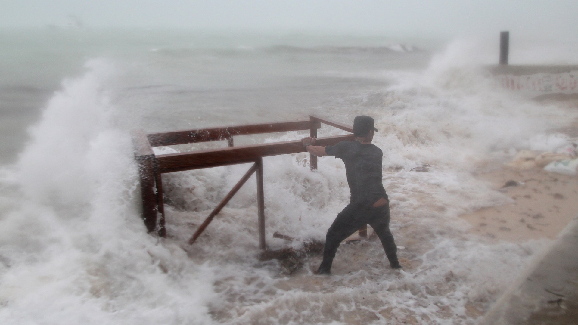 A man tries to salvage a table from his restaurant before the arrival of Hurricane Maria in Punta Cana, Dominican Republic, Wednesday