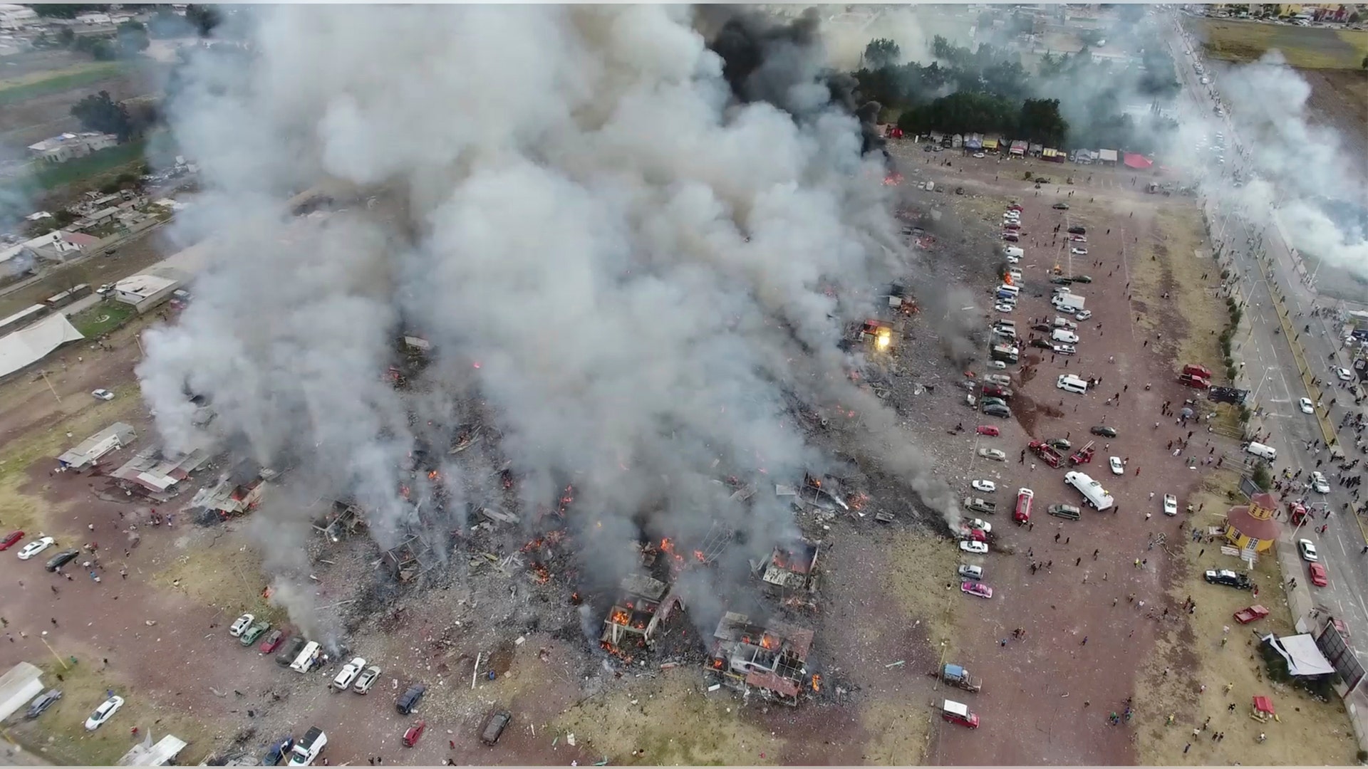 A view from a drone shows smoke billowing from the San Pablito fireworks market after the explosion, with most of the stands entirely leveled. Sirens wailed and a heavy scent of gunpowder lingered in the air after the afternoon.