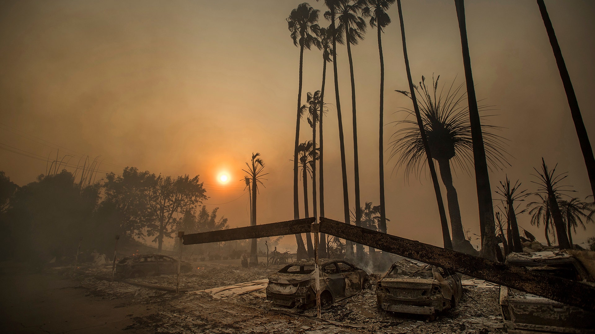 Smoke rises behind a leveled apartment complex as a wildfire burns in Ventura, California, Tuesday