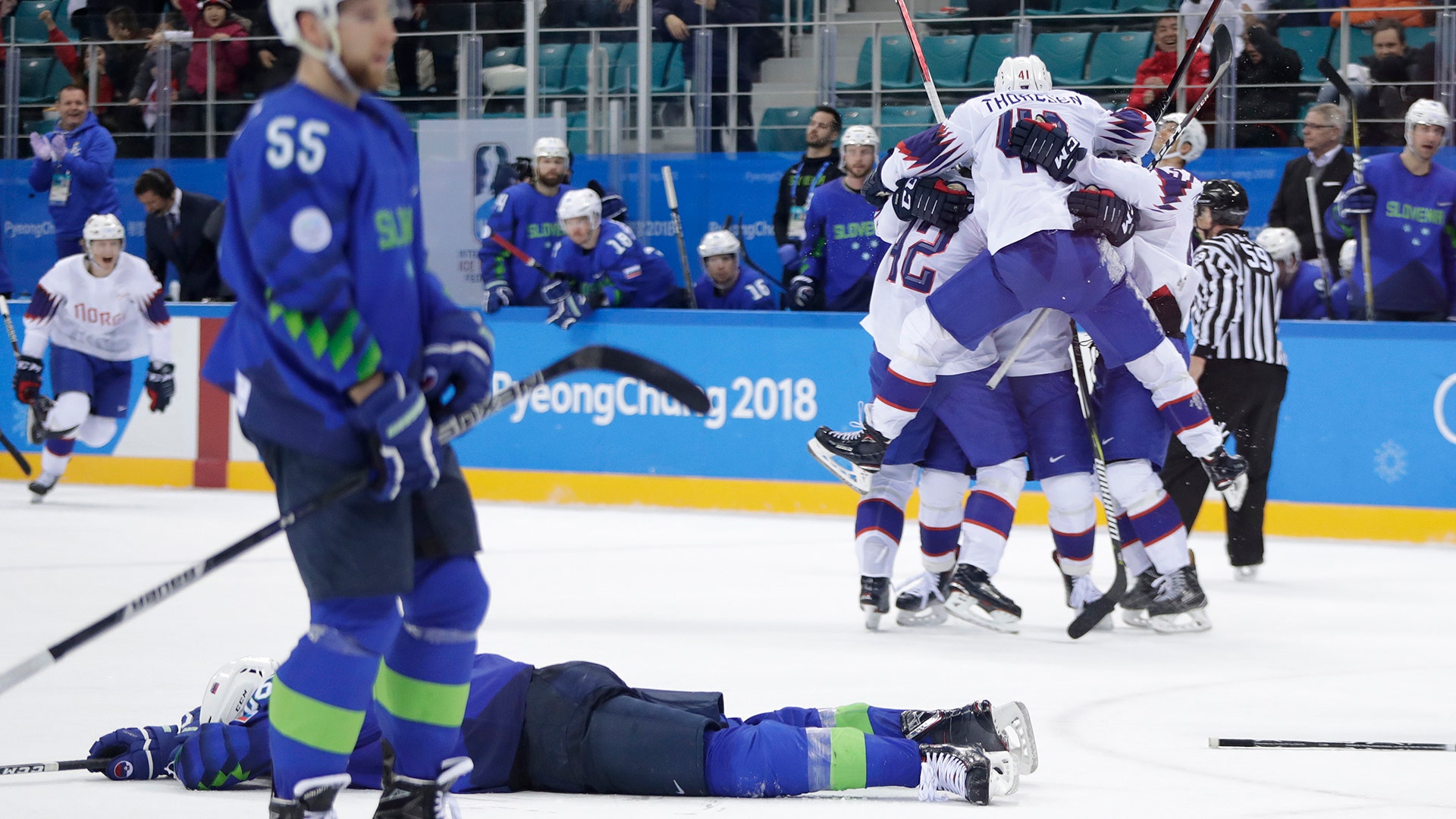 Norway players celebrate after winning their qualification round men's ice hockey game against Slovenia at the Winter Olympics
