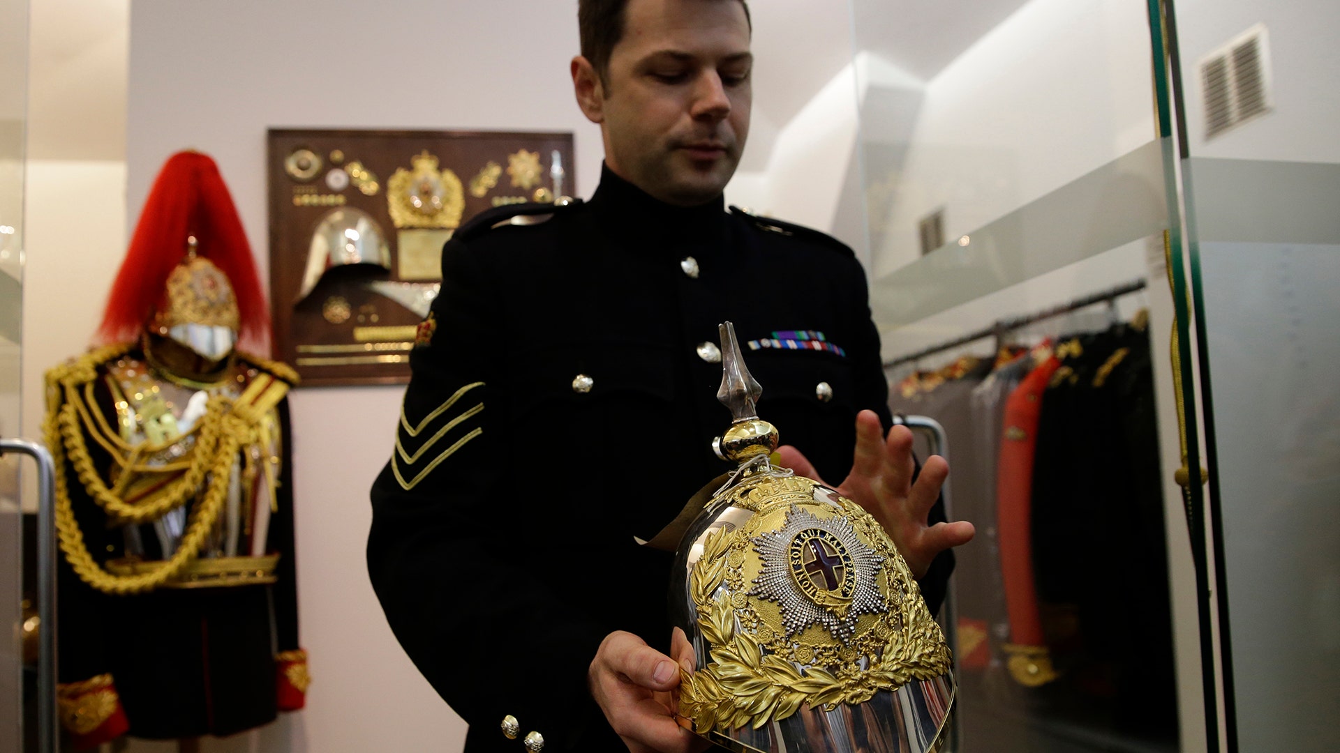 Corporal of the Horse, John Brophy shows off a helmet designed by the husband of Queen Victoria, at the units barracks in London, May 9, 2018