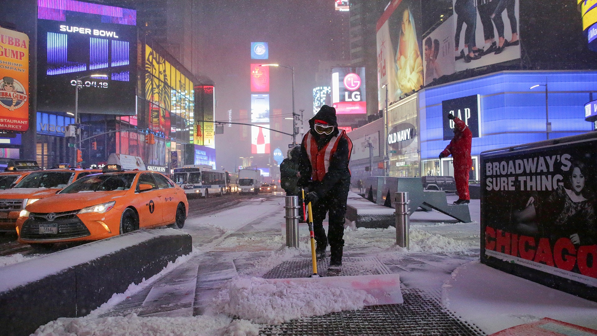 Workers remove snow during a snowstorm in Times Square in New York City, Thursday