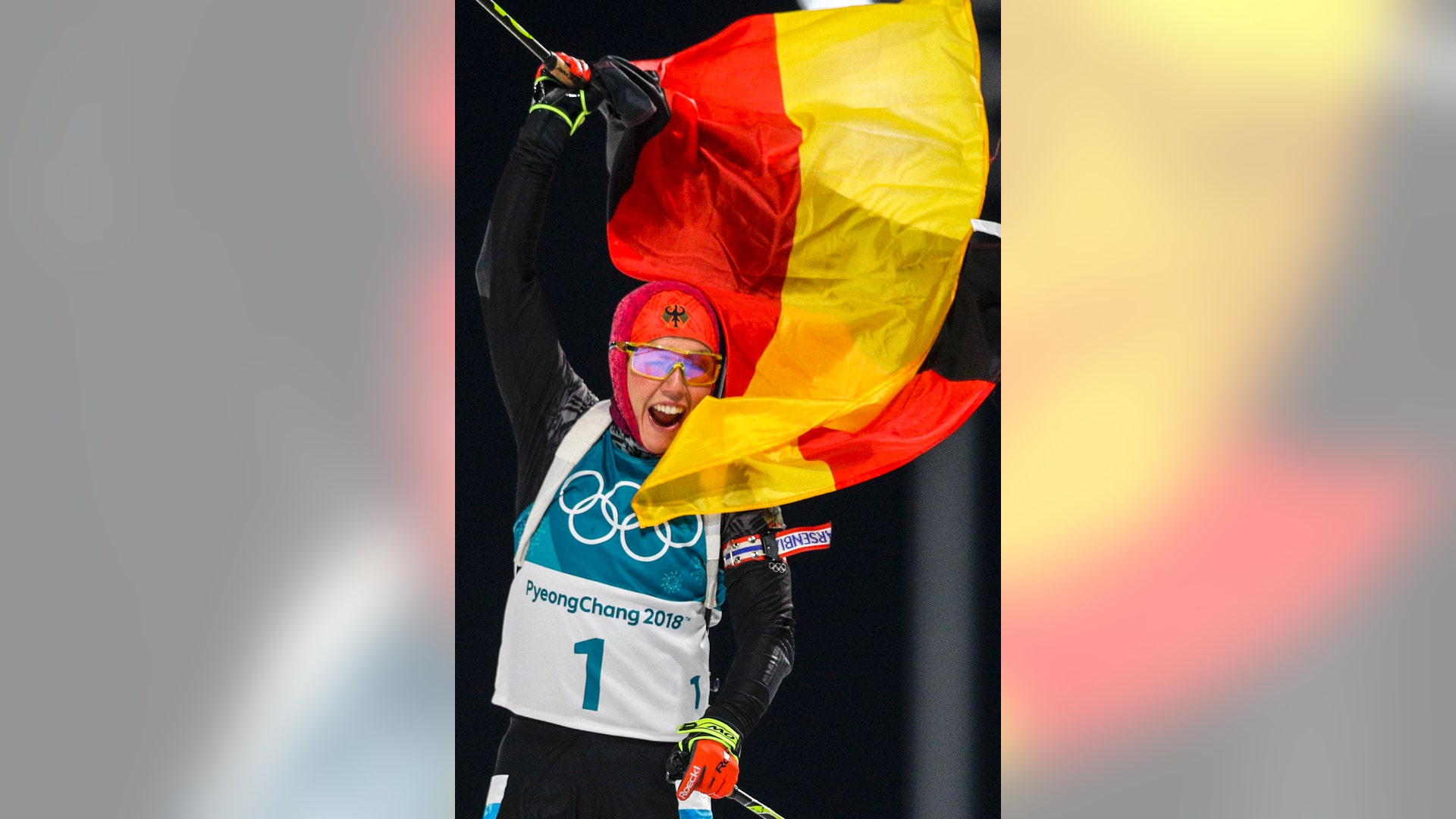Laura Dahlmeier waves the German flag as she wins the gold medal in the women's 10-kilometer biathlon pursuit at the 2018 Winter Olympics