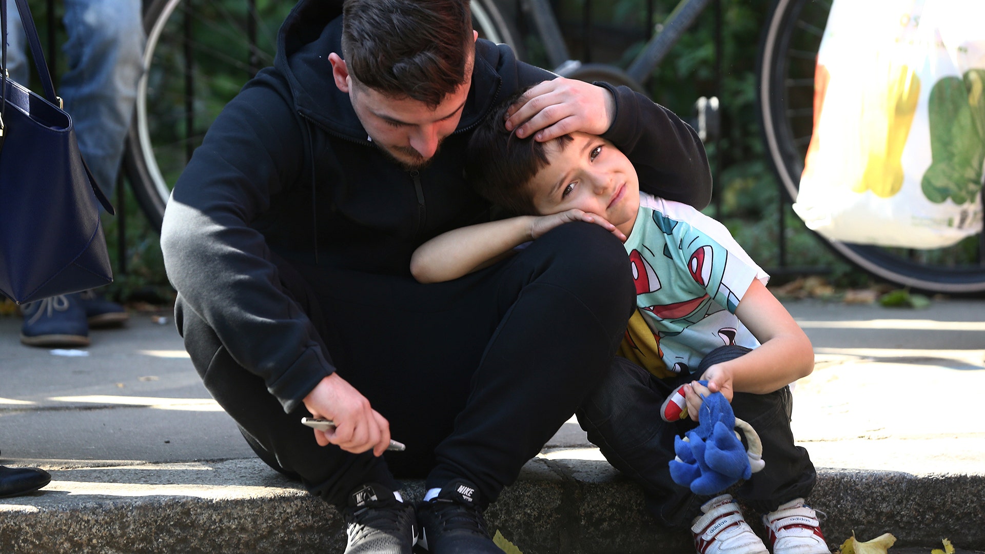 A man comforts a boy after the apartment building fire, in north Kensington, West London