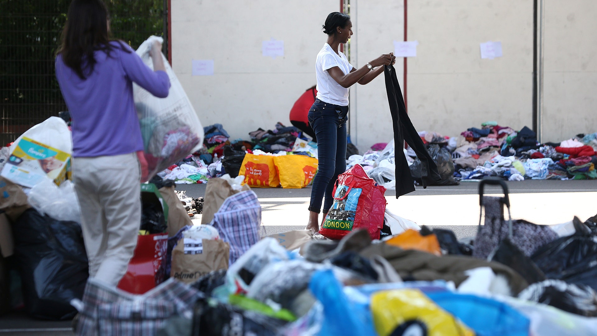 People go through clothing and other supplies donated for victims of the apartment fire in London