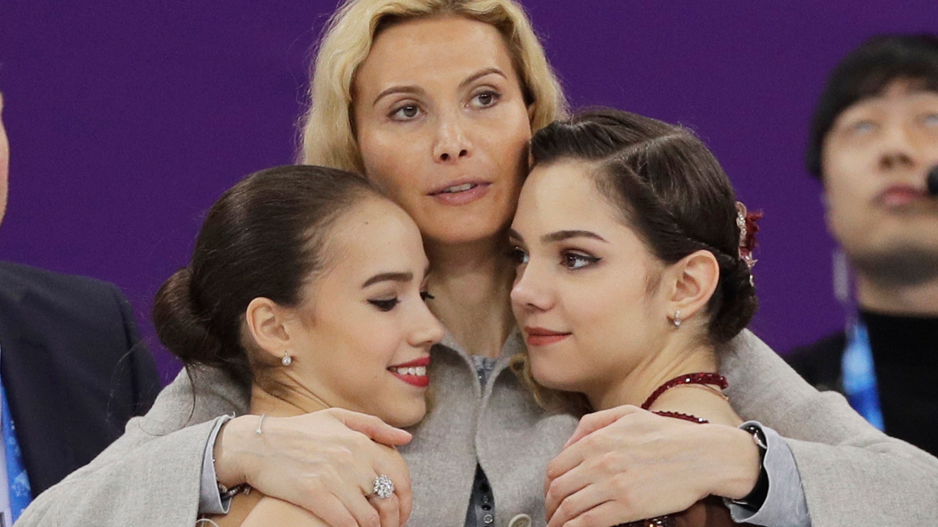 Russian figure skating coach Eteri Georgievna Tutberidze hugs gold medalist Alina Zagitova and silver medalist Evgenia Medvedeva