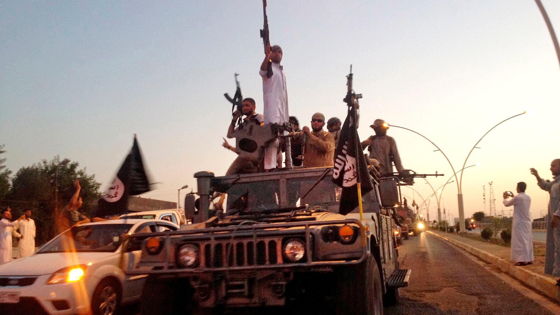 Fighters from the Islamic State in a commandeered Iraqi security forces armored vehicle on the main road in Mosul, Iraq, June 23, 2014