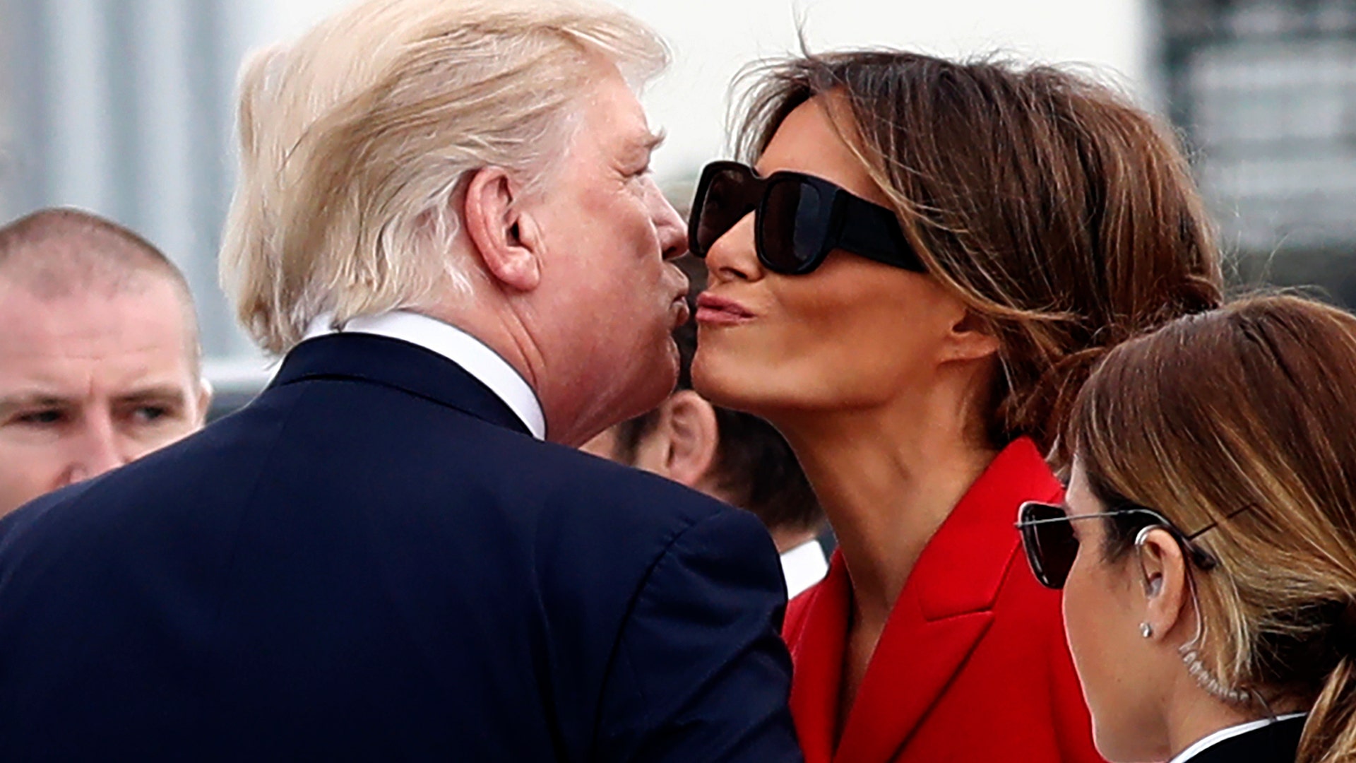 President Donald Trump and first lady Melania Trump kiss on the tarmac after arriving on Air Force One at Orly Airport in Paris