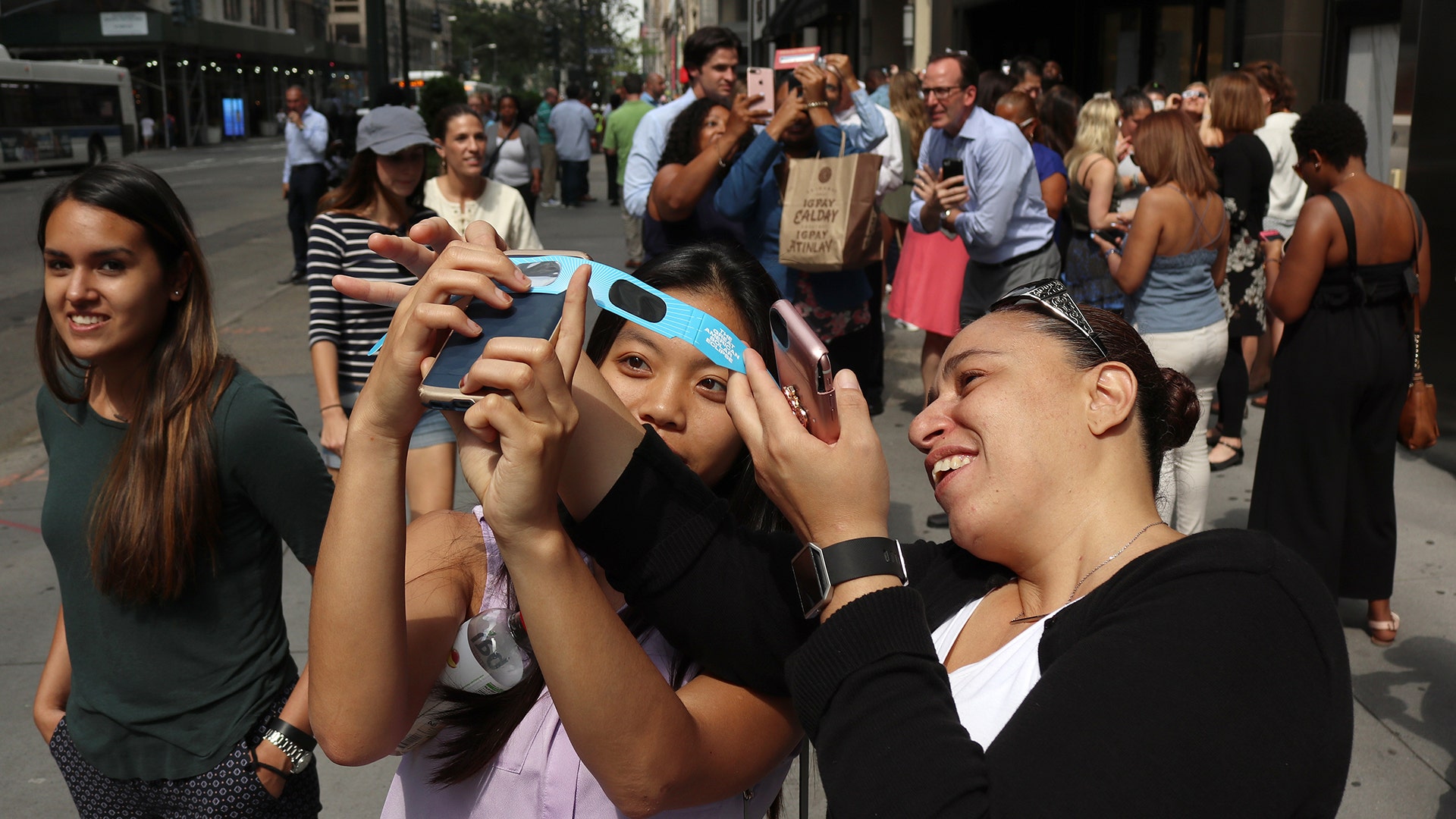 People watch the solar eclipse on 5th Avenue in New York