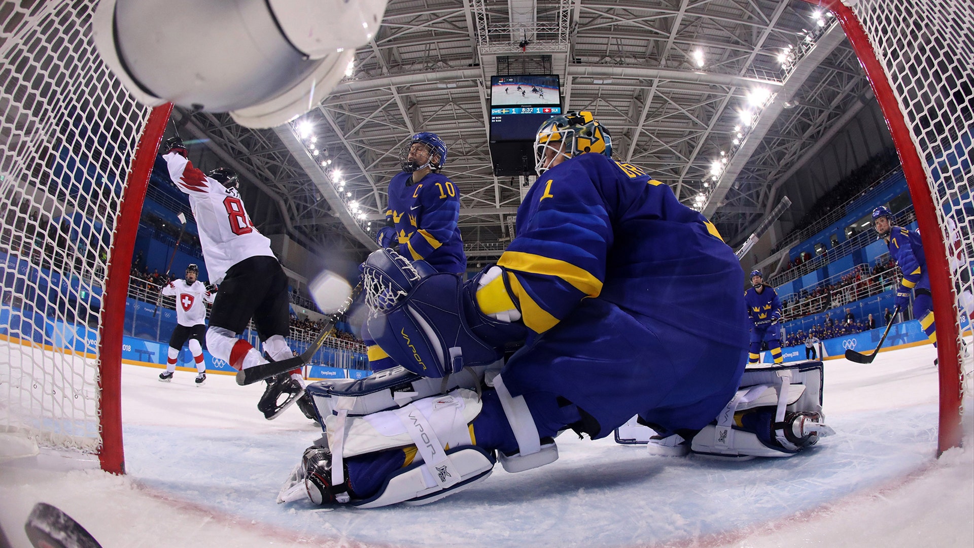 Phoebe Staenz of Switzerland celebrates scoring past goalkeeper Sara Grahn of Sweden in their ice hockey game at the 2018 Winter Olympics 