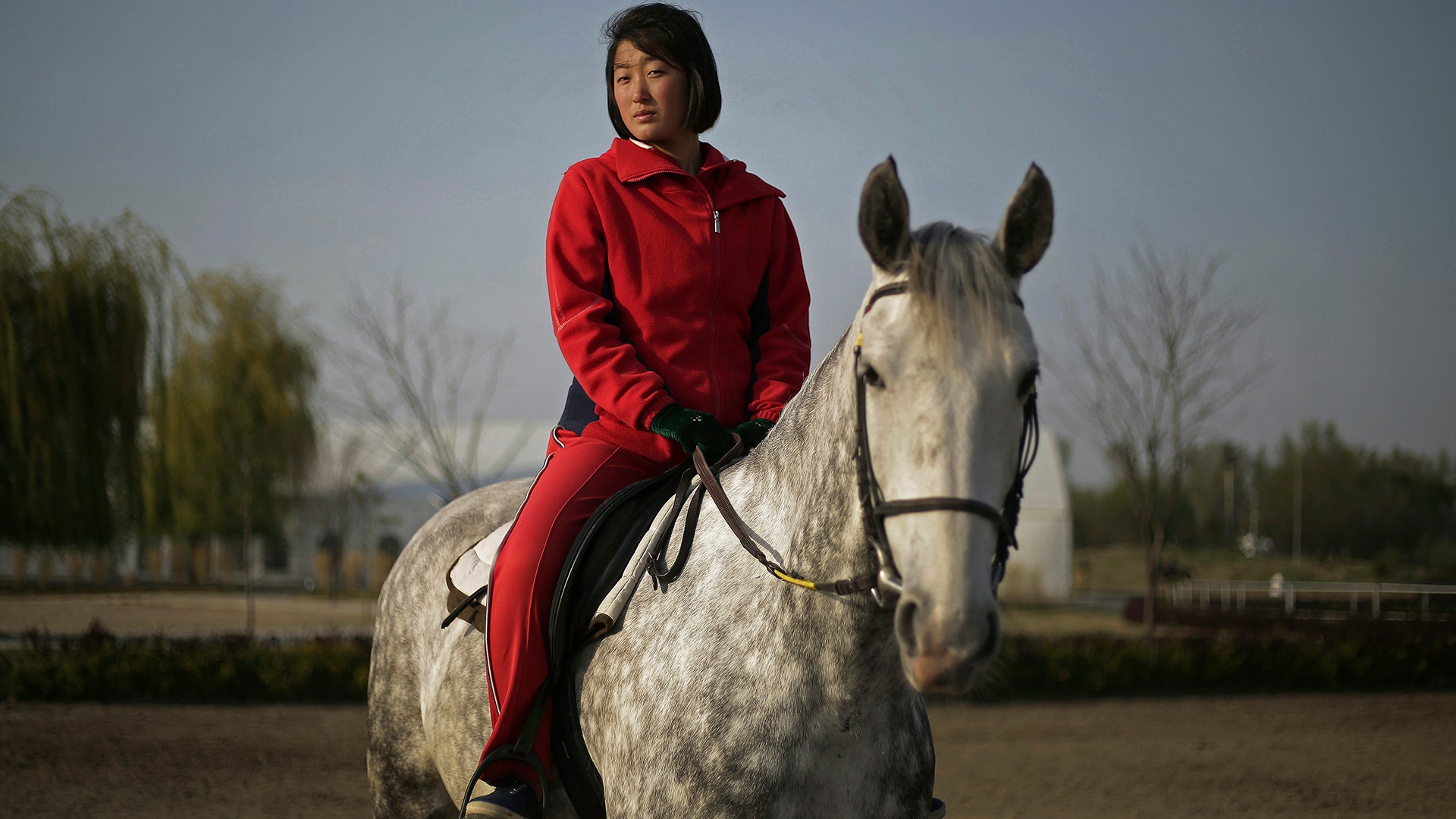 Pak Hyon Sun, 18, poses on a horse at the Mirim Riding Club, in Pyongyang, North Korea, April 20, 2017