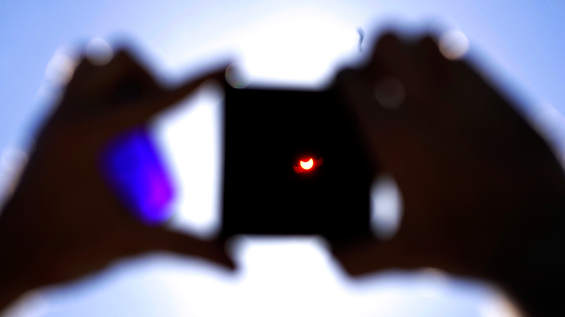 A man using a special filter observes a partial solar eclipse in Riga, Latvia, August 1, 2008