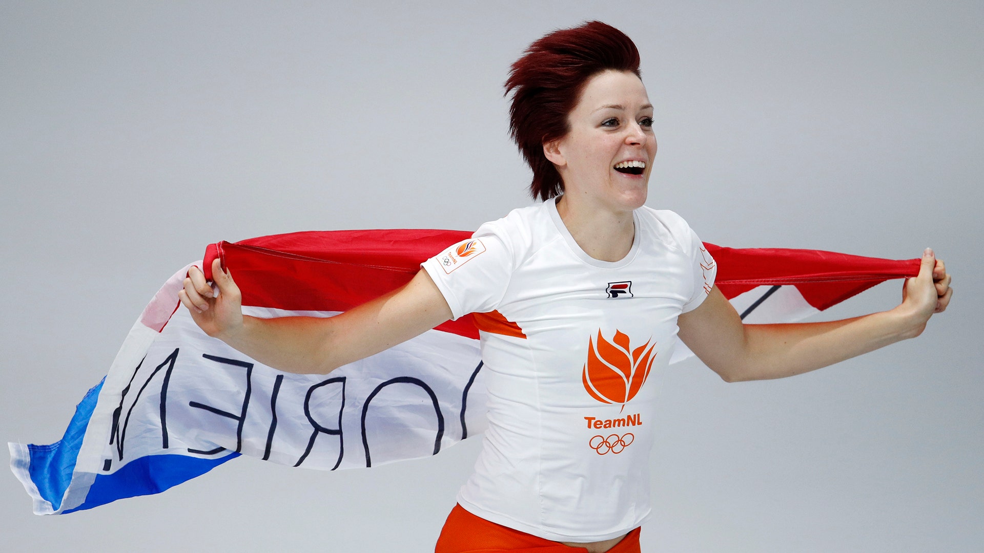 Gold medallist Jorien ter Mors of The Netherlands celebrates with the national flag after the women's 1,000 meters speedskating race